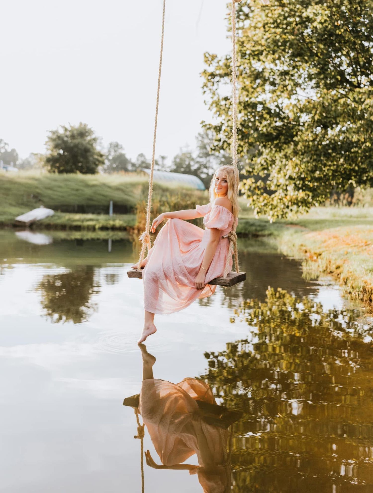 senior session over pond on swing