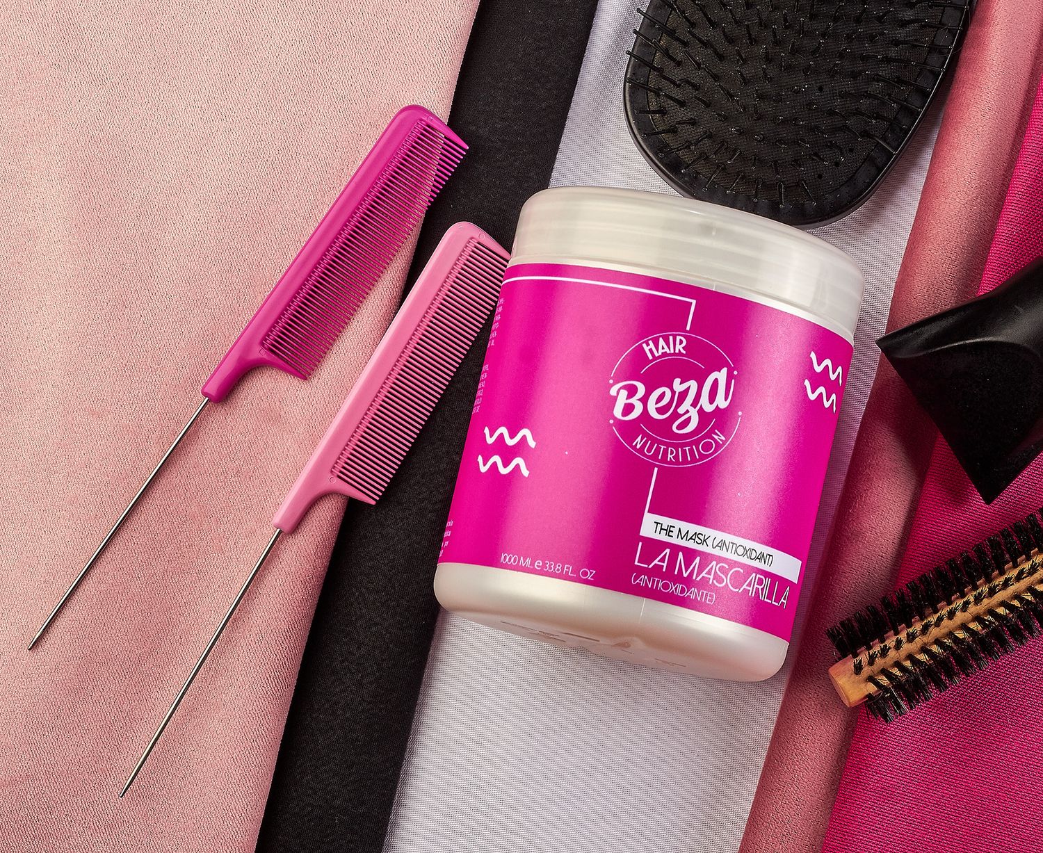 Beza Hair Nutrition La Mascarilla pink hair mask jar surrounded by styling combs on light fabric background.