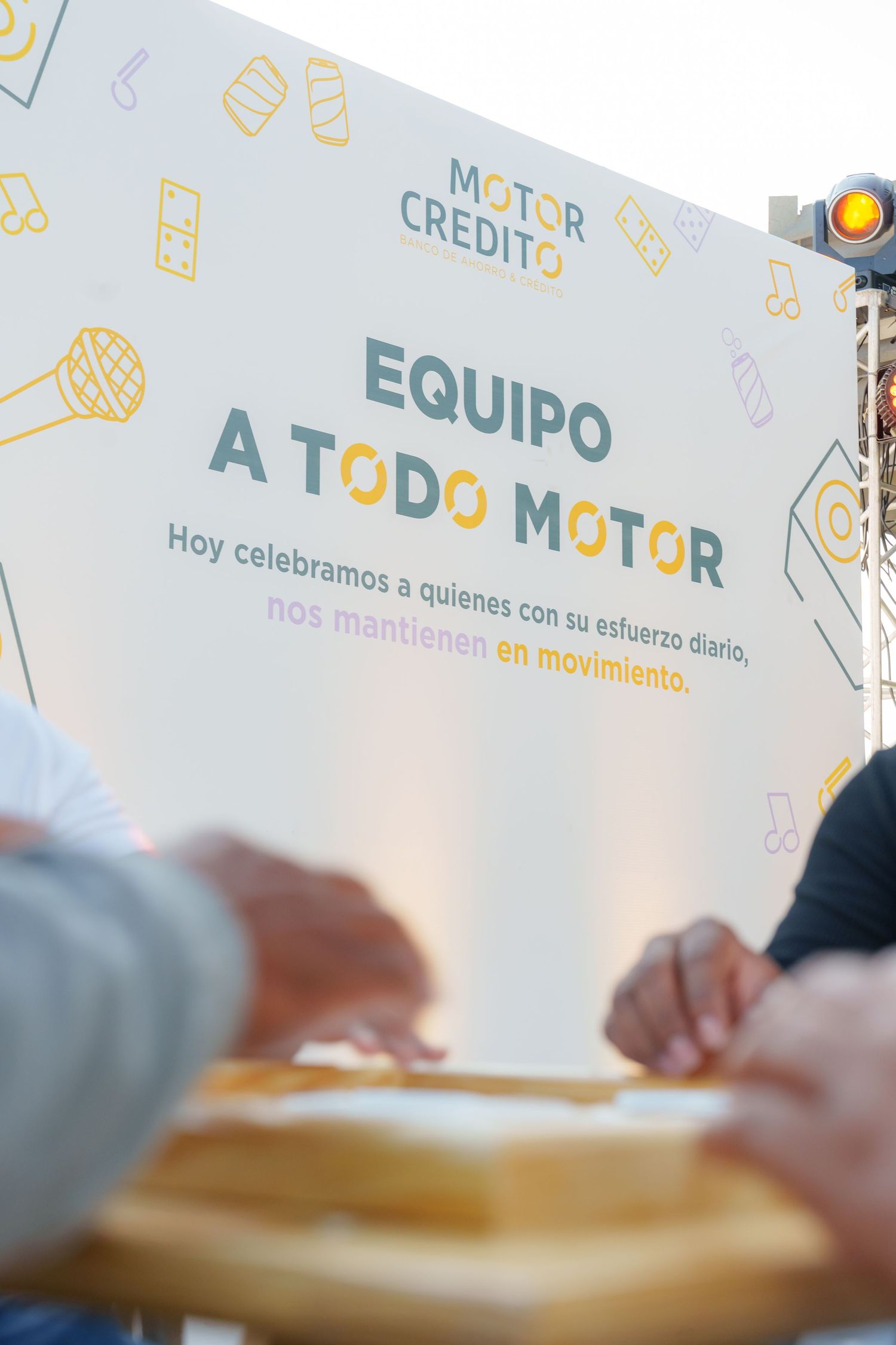 Motor Credito event banner reading Equipo a Todo Motor celebrating team members at an outdoor corporate event.