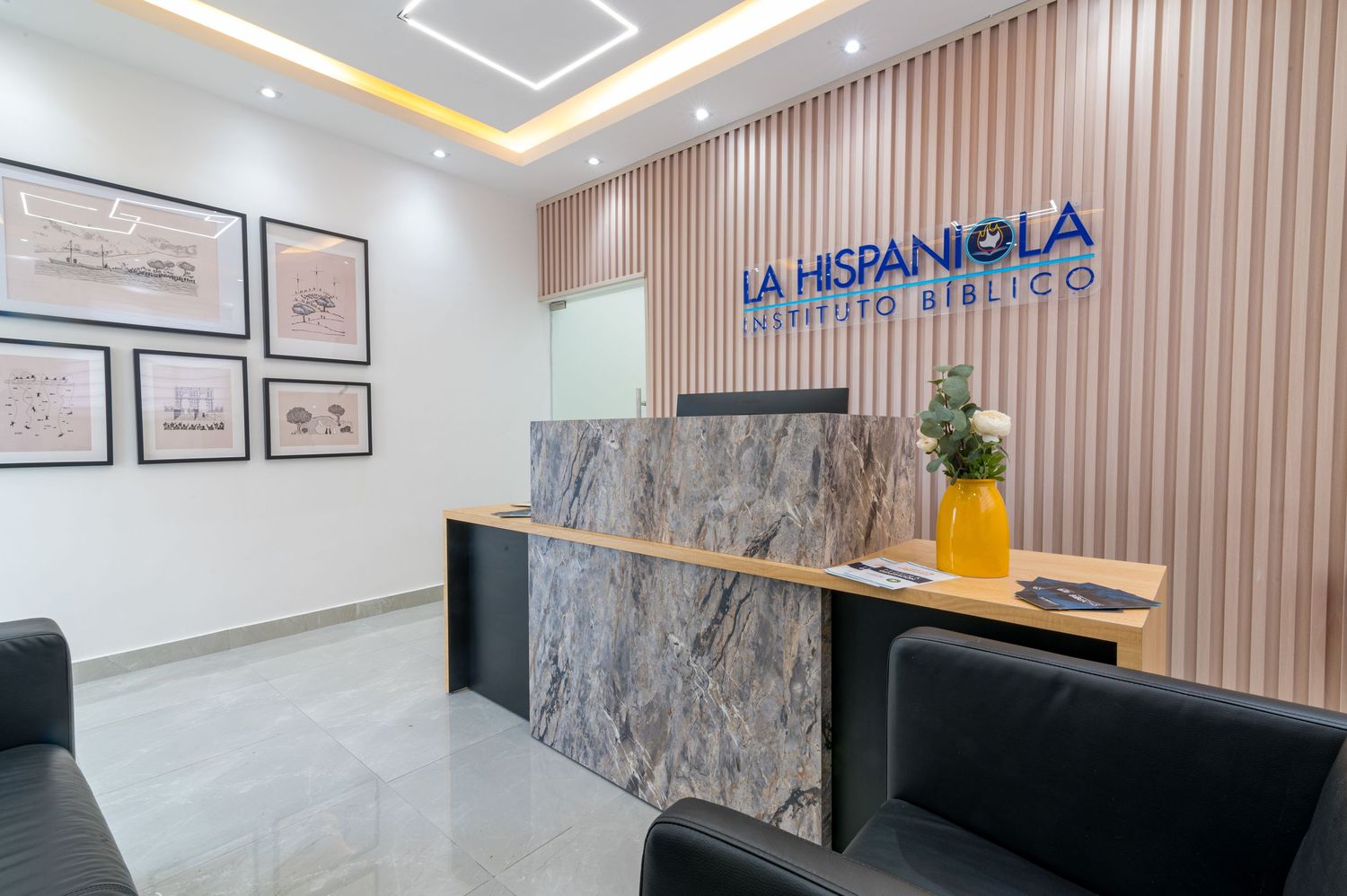 La Hispaniola Instituto Biblico reception desk with marble finish, framed artwork, and modern interior design.