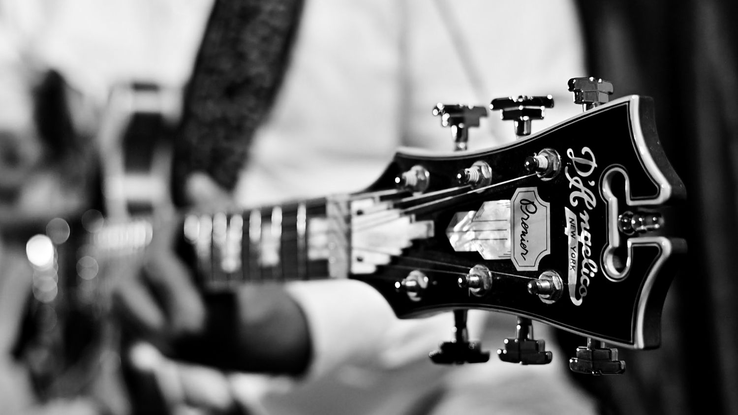 Close-up black and white photo of a DeArmond electric guitar headstock with tuning pegs in focus.