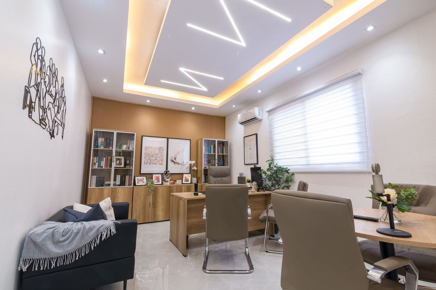 Elegant office space featuring geometric LED ceiling design, wood cabinetry, and stylish neutral-toned furniture.