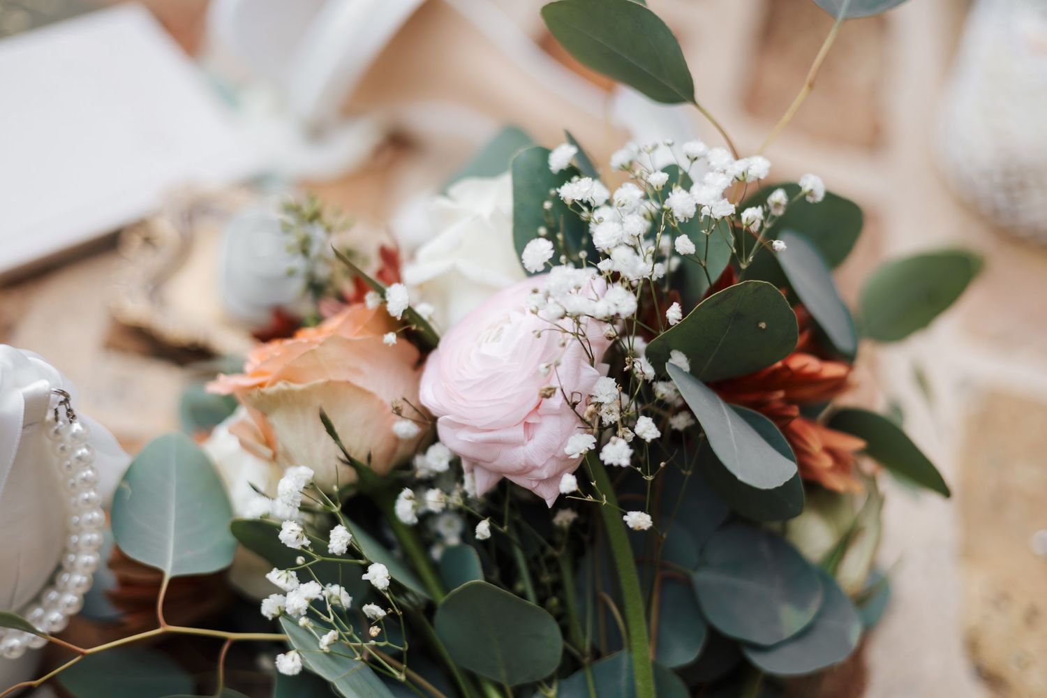 Elegant wedding bouquet with pink peonies, white baby's breath, and eucalyptus greenery.