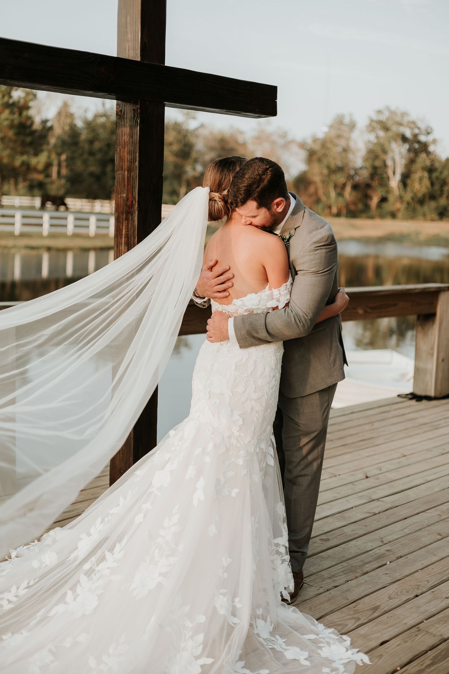 Wedding couple sharing intimate moments on a wooden dock by the water.