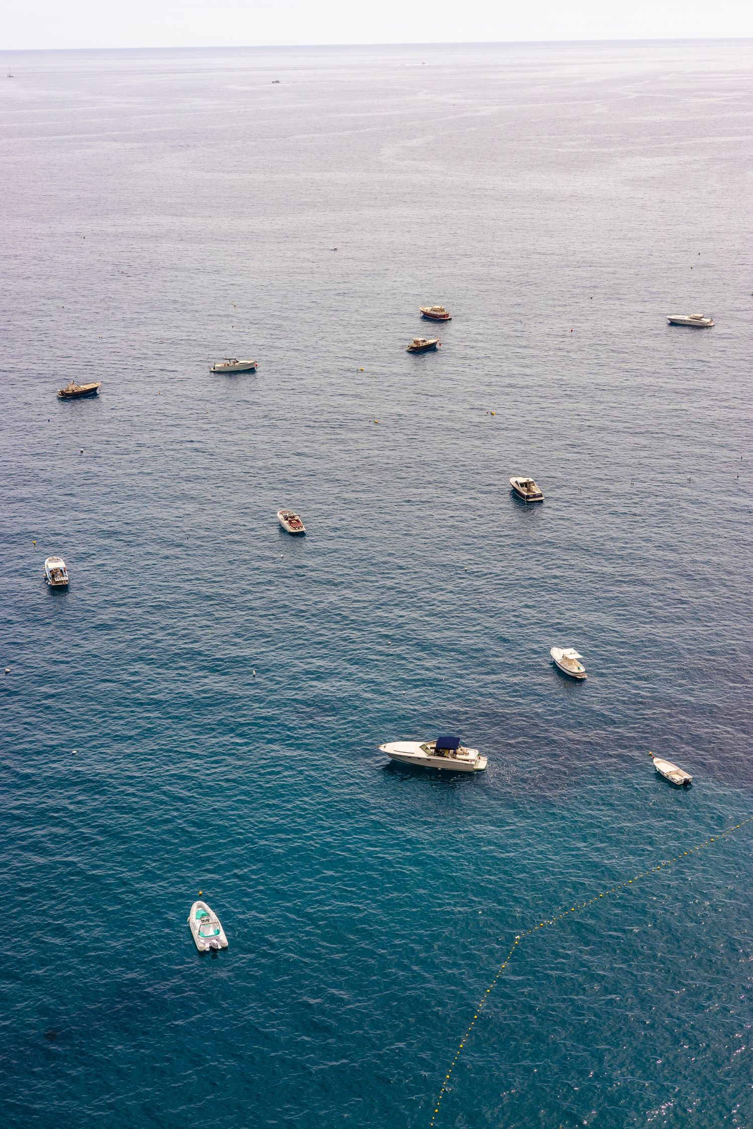 Aerial view of boats on calm blue water, travel photography capturing serene coastal landscape and minimal composition