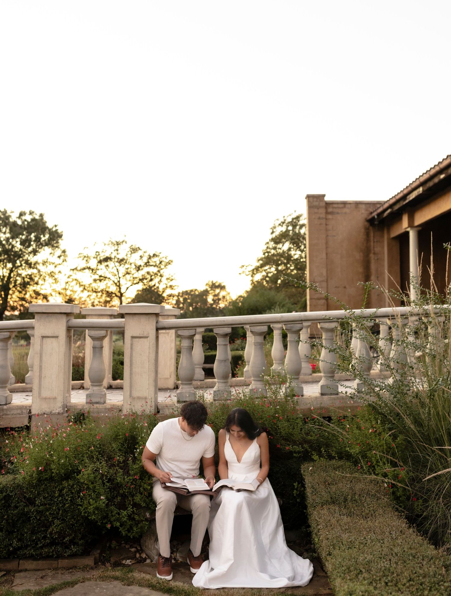 Couple sitting on stone steps reading together at golden hour sunset.