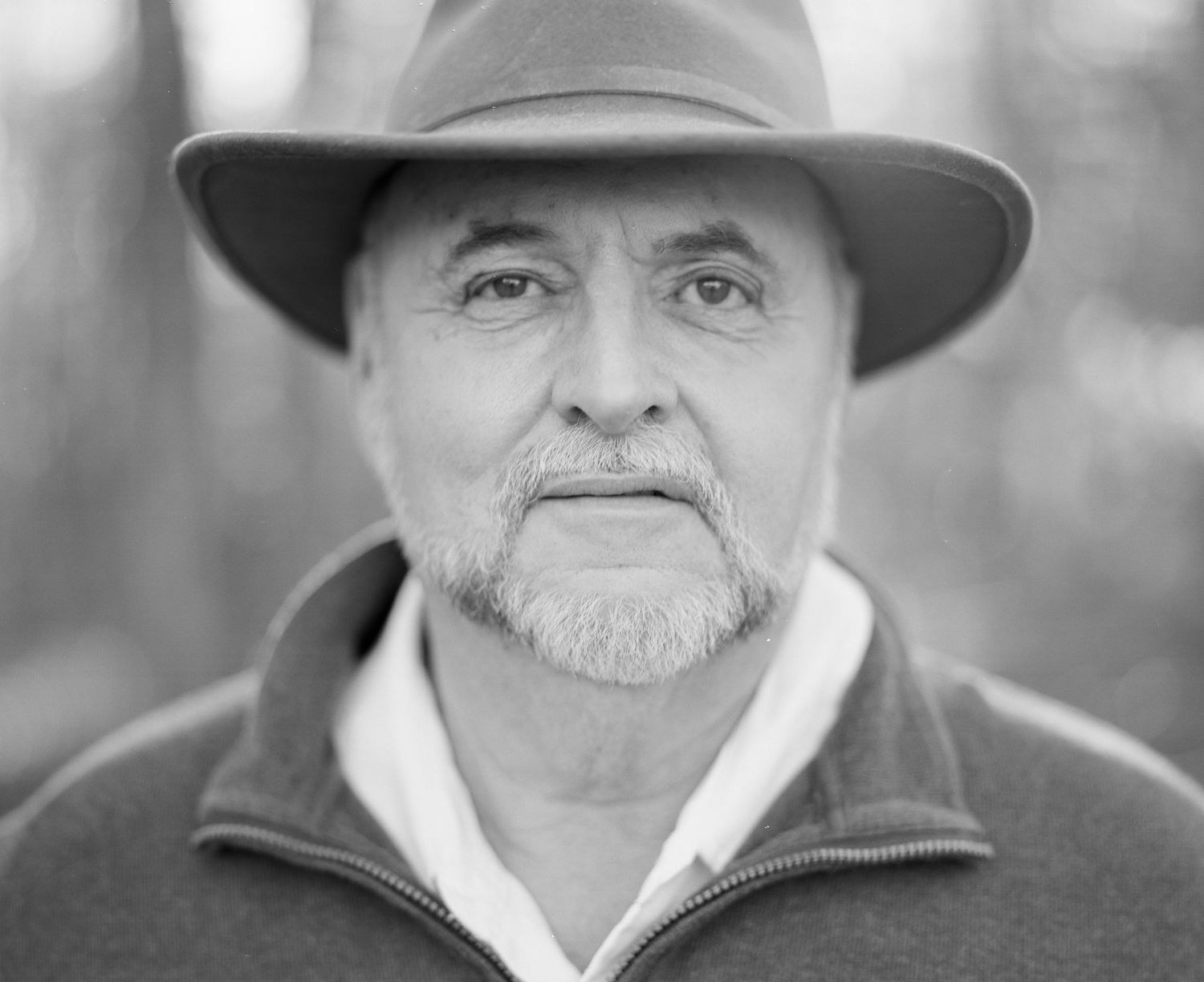 Series of black and white headshots showing person in hat and collared shirt.