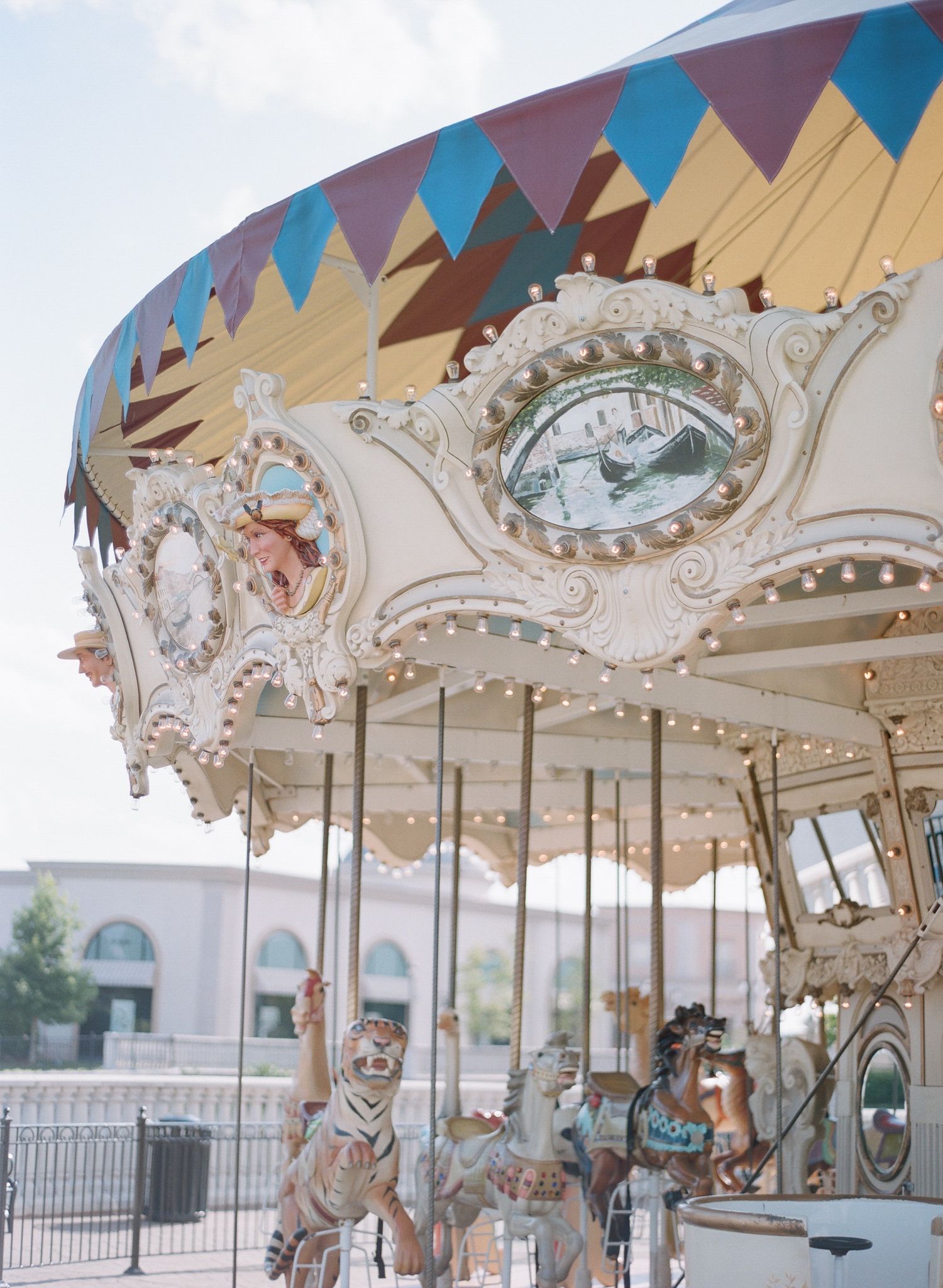 Side view of classic carousel with geometric pattern canopy and decorated horses.