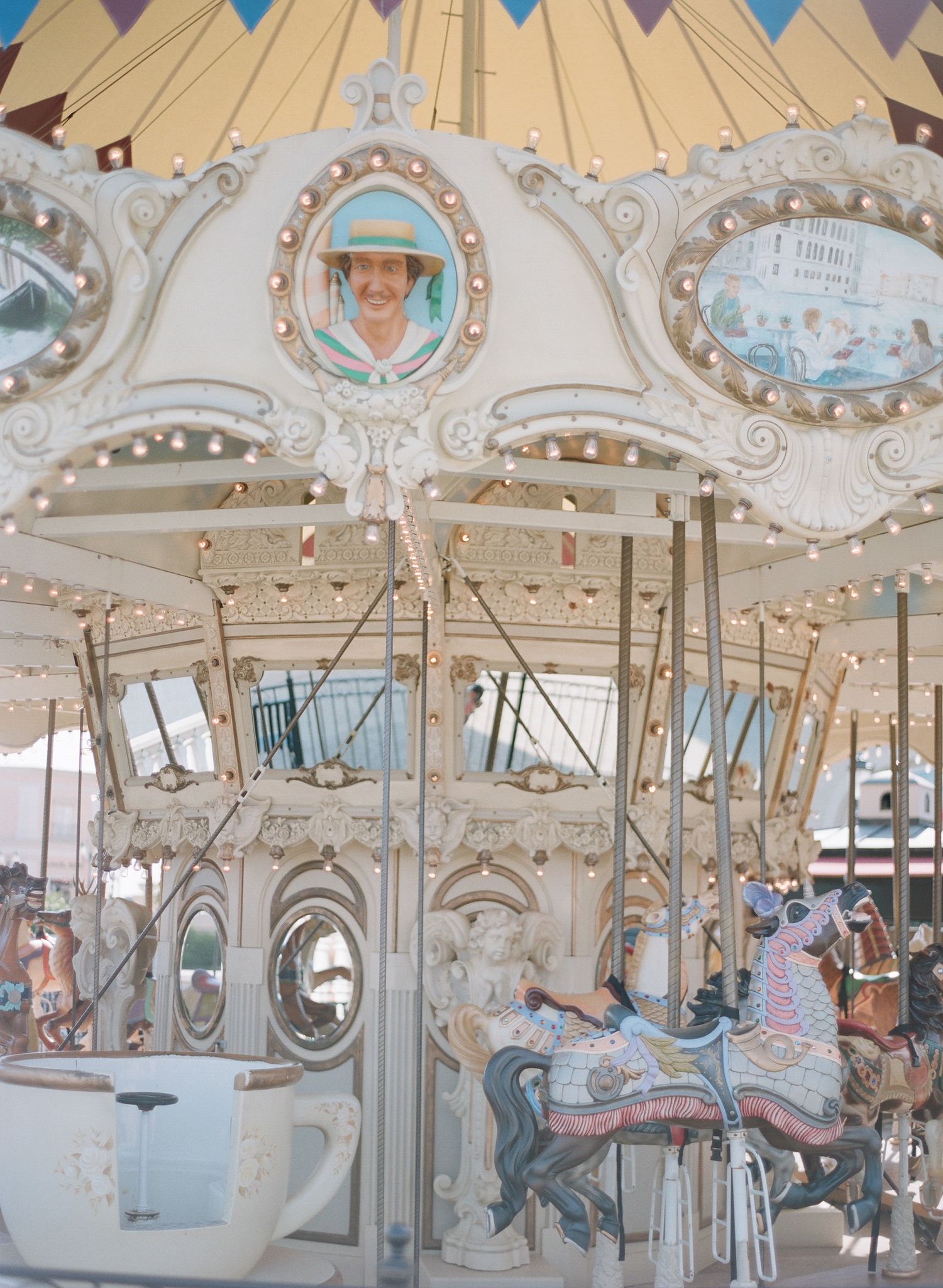 Ornate carousel with colorful bunting and decorative mirrors under carnival lighting.