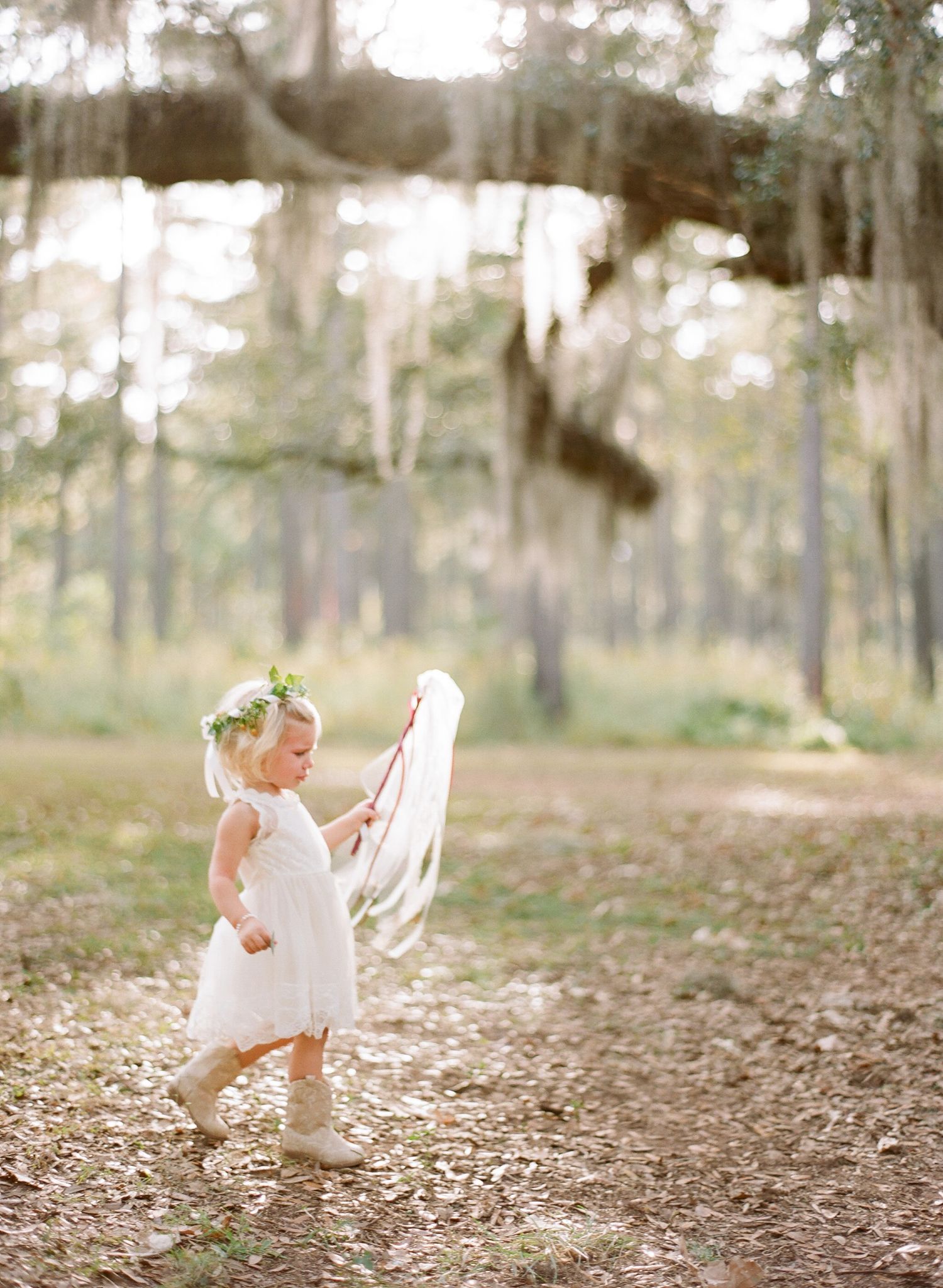A series of ethereal photos showing a small figure in white moving through a wooded outdoor setting.