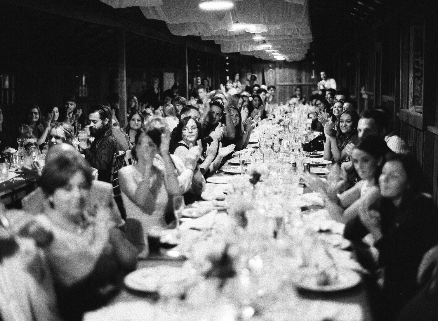 Black and white reception scene with elegant table settings and ambient lighting.