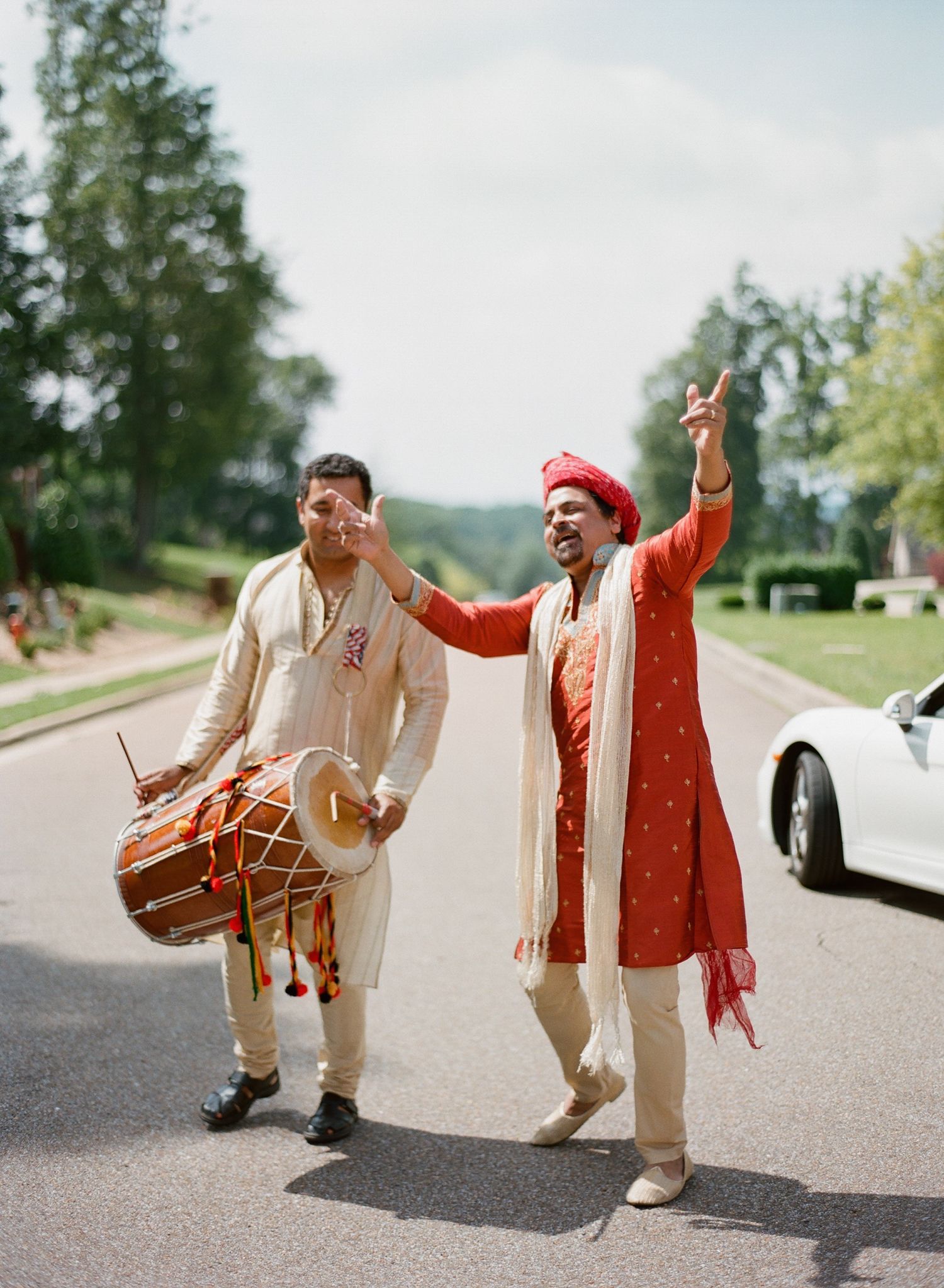 Celebratory dance with dhol drum during Indian wedding baraat procession.