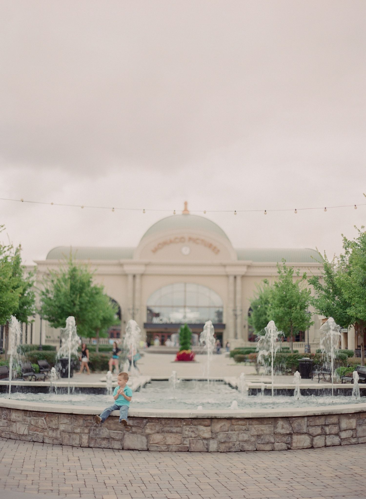 Panoramic view of an elegant stone fountain plaza with white architectural features.