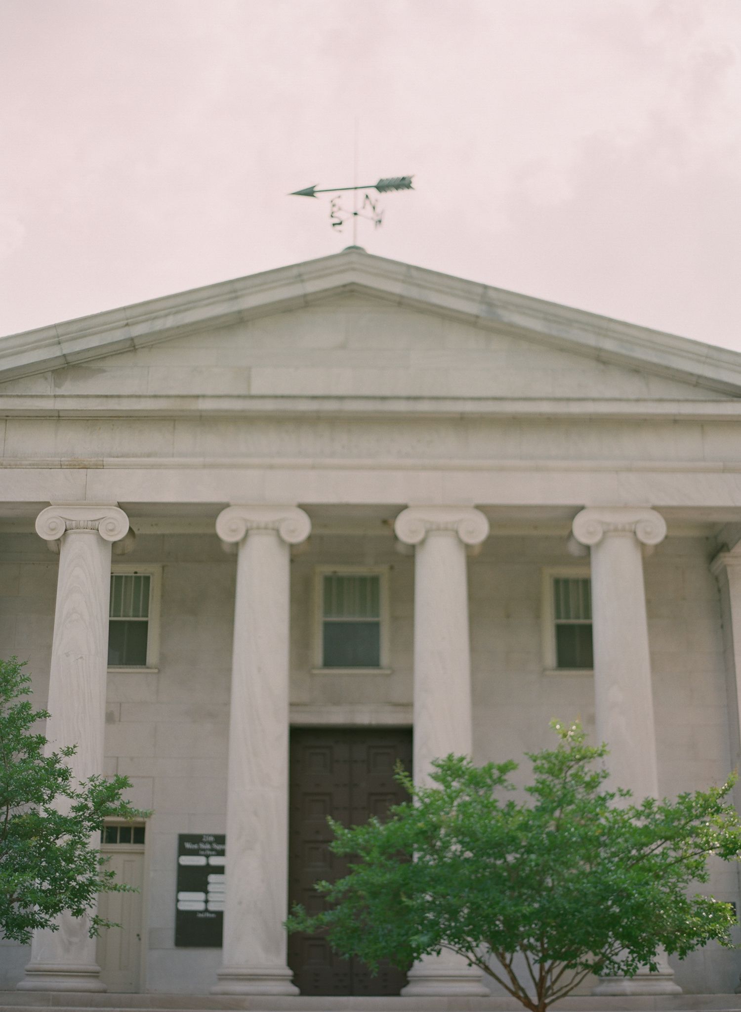 Classical white building facade with Ionic columns and symmetrical architecture.