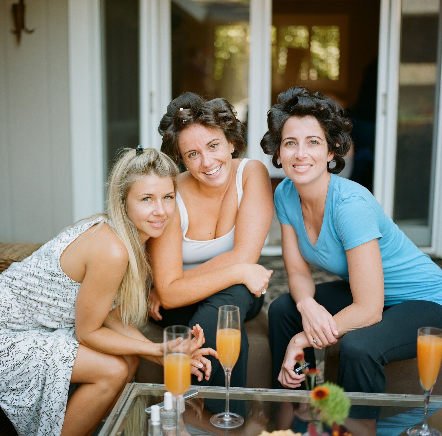 Friends relaxing together on a patio with drinks and snacks during a casual gathering.