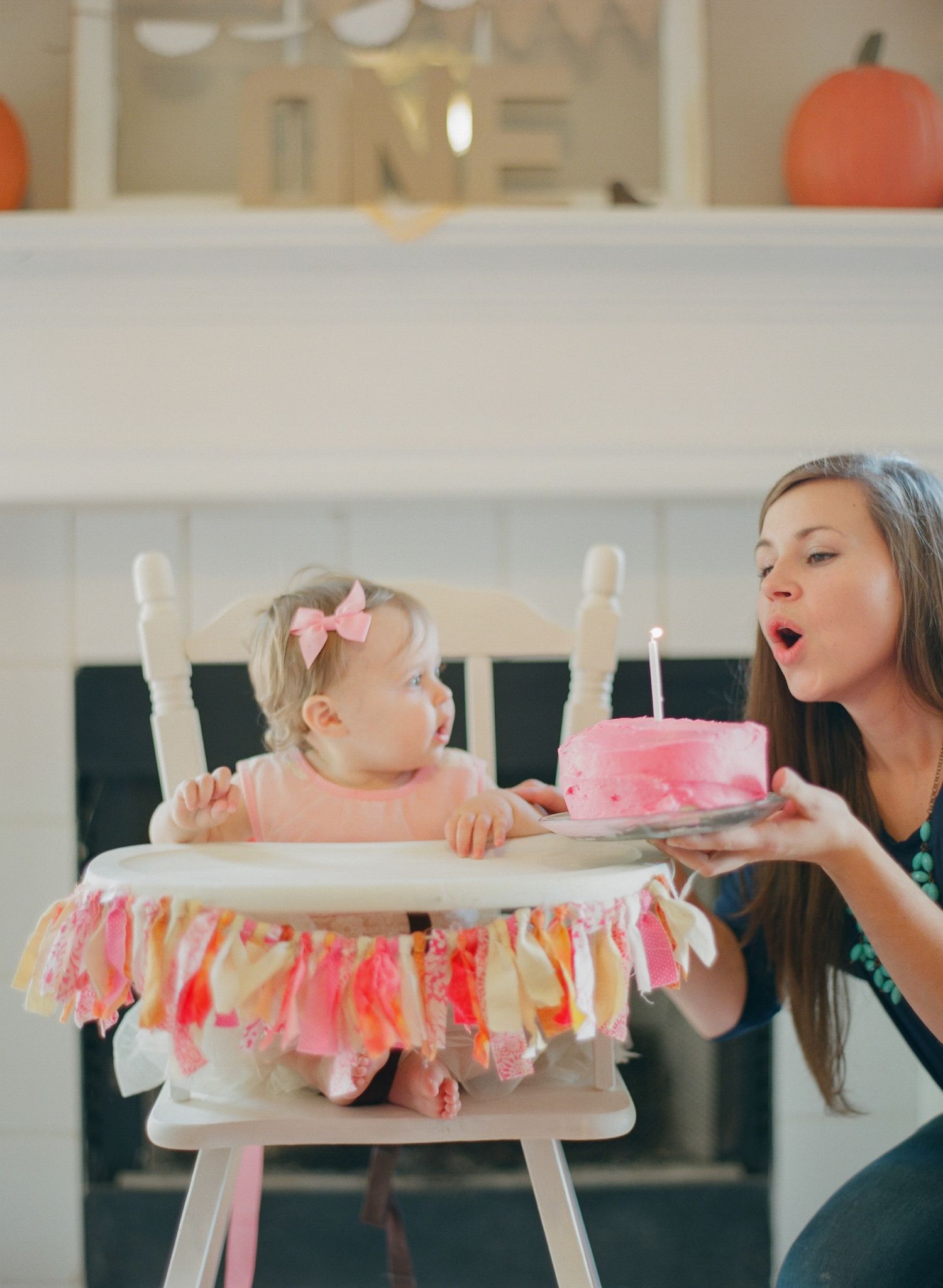 Decorated high chair with pink garland being prepared for celebration.