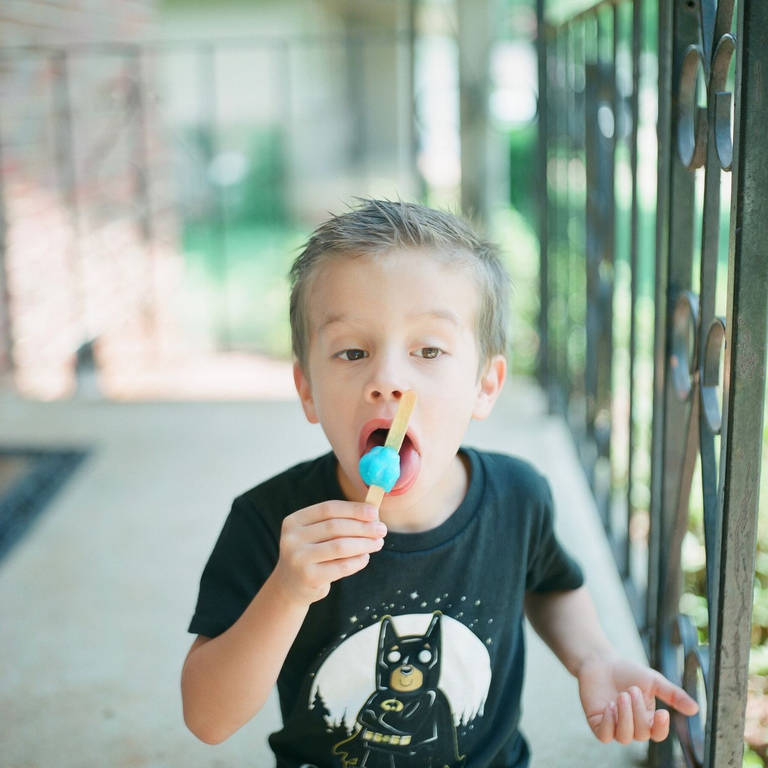 A series of photos showing a child eating a blue popsicle.