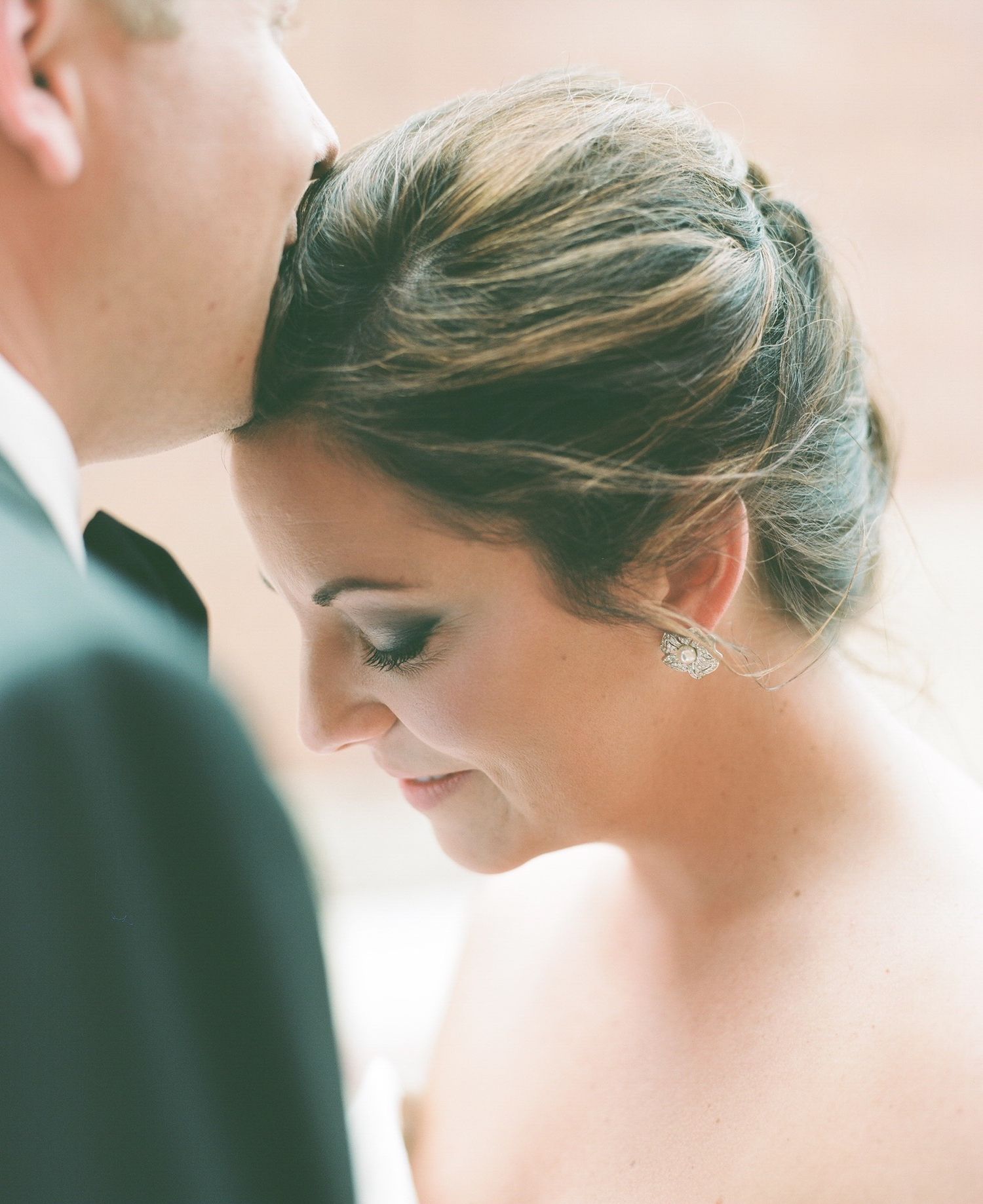 Elegant wedding hairstyle detail with crystal hair accessory in soft focus.