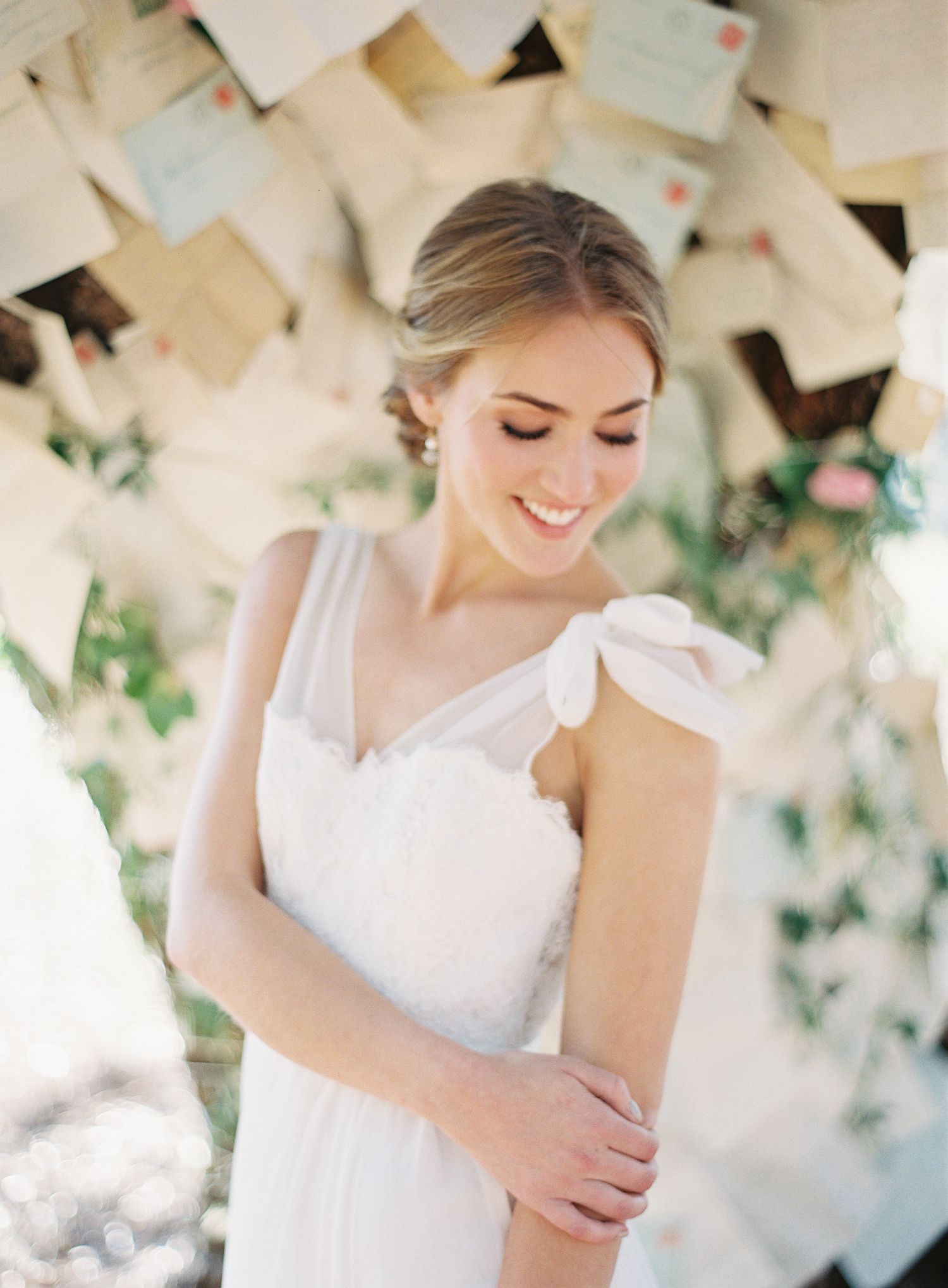 A delicate white bridal gown is showcased against a backdrop of hanging paper decorations.