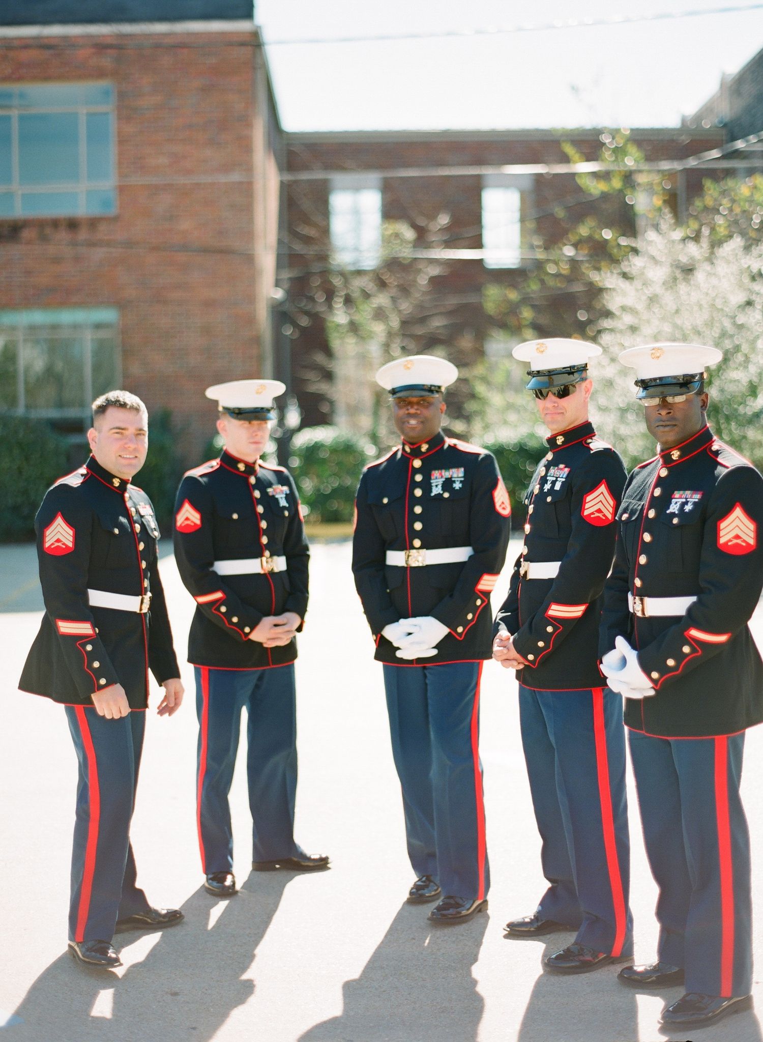Line of U.S. Marines in dress uniforms standing at attention during formal ceremony.