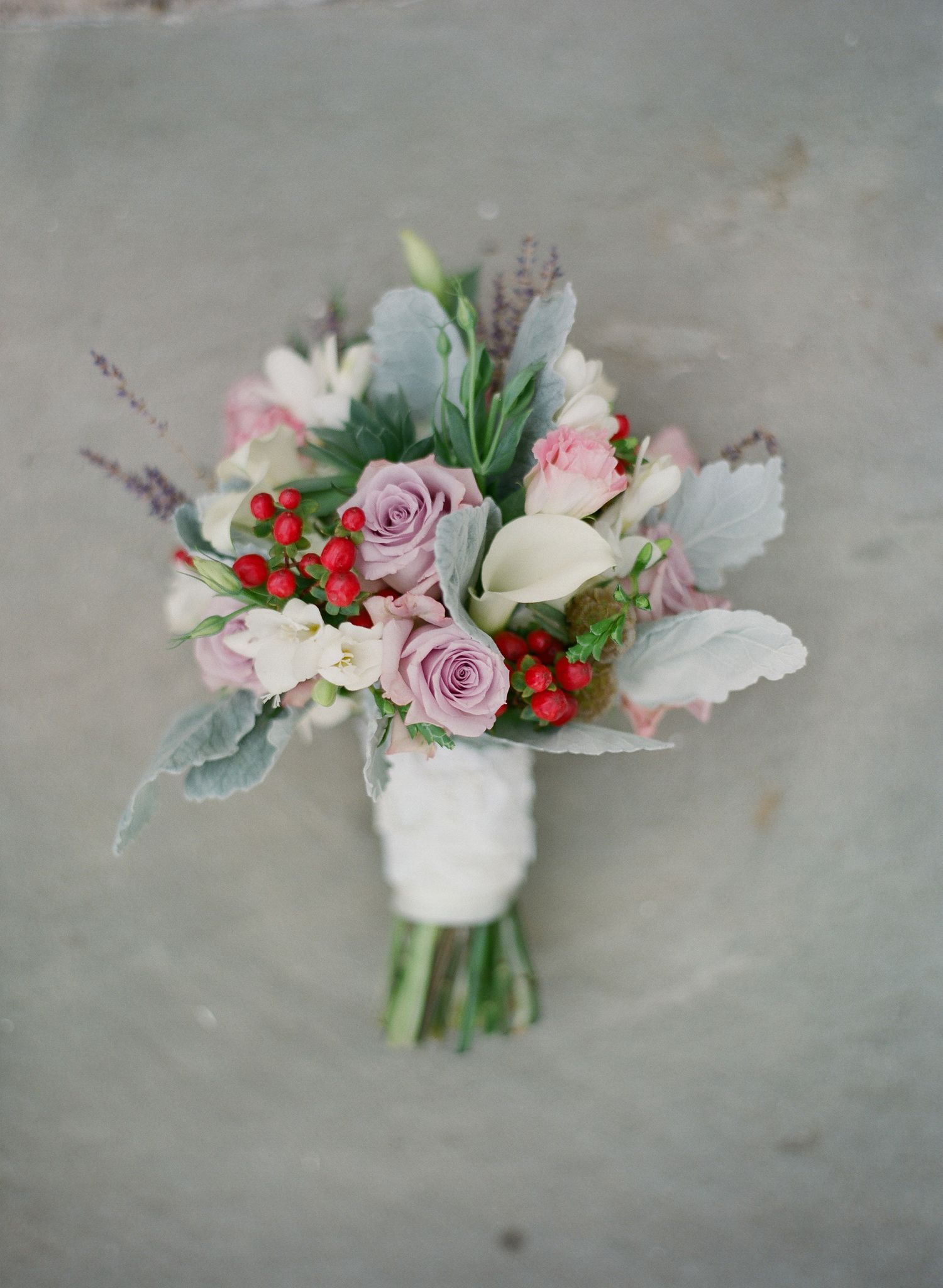 Romantic bridal bouquet with pink roses, red berries and white flowers.