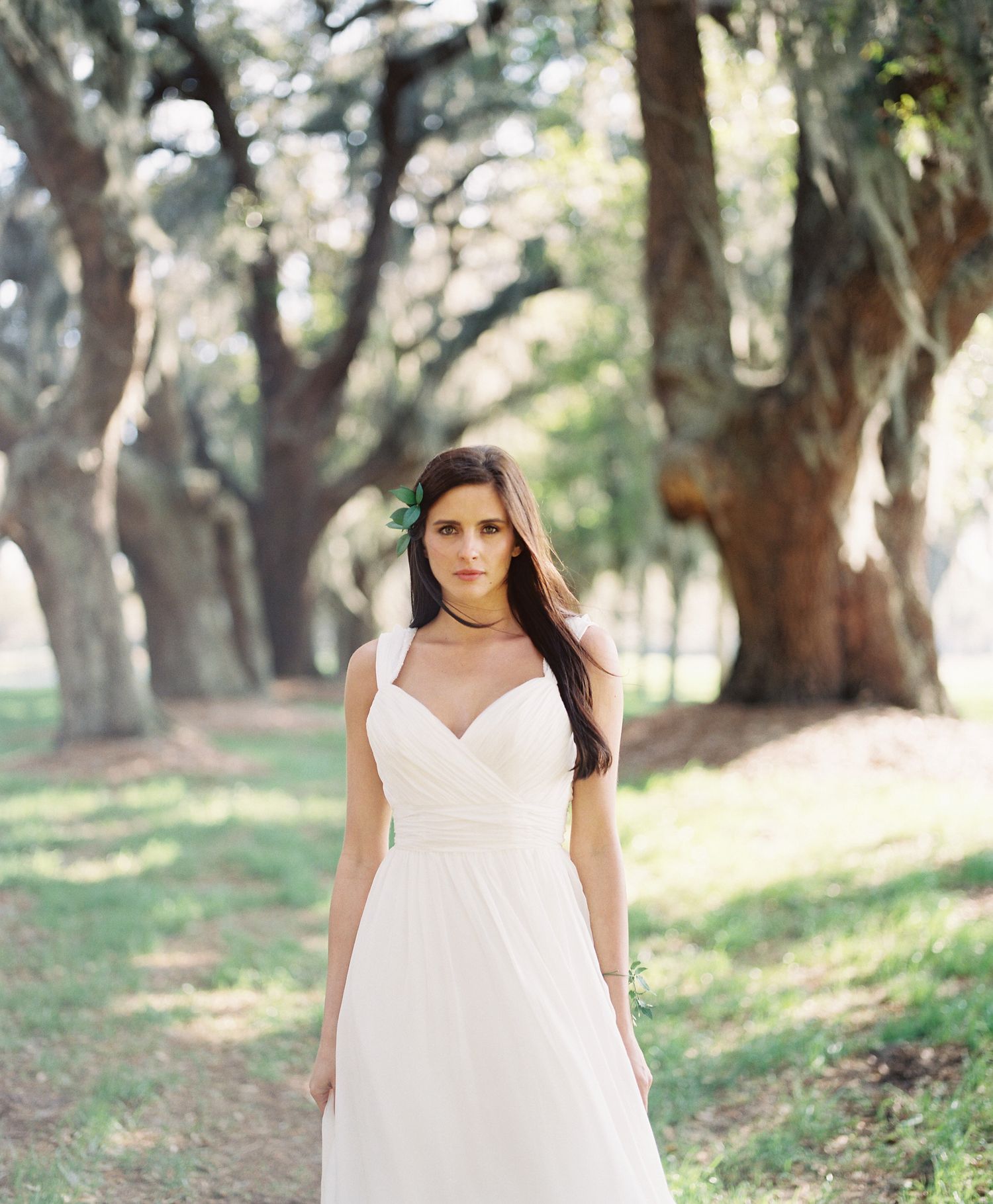 White wedding dress photographed in a series against a wooded outdoor backdrop with Spanish moss.