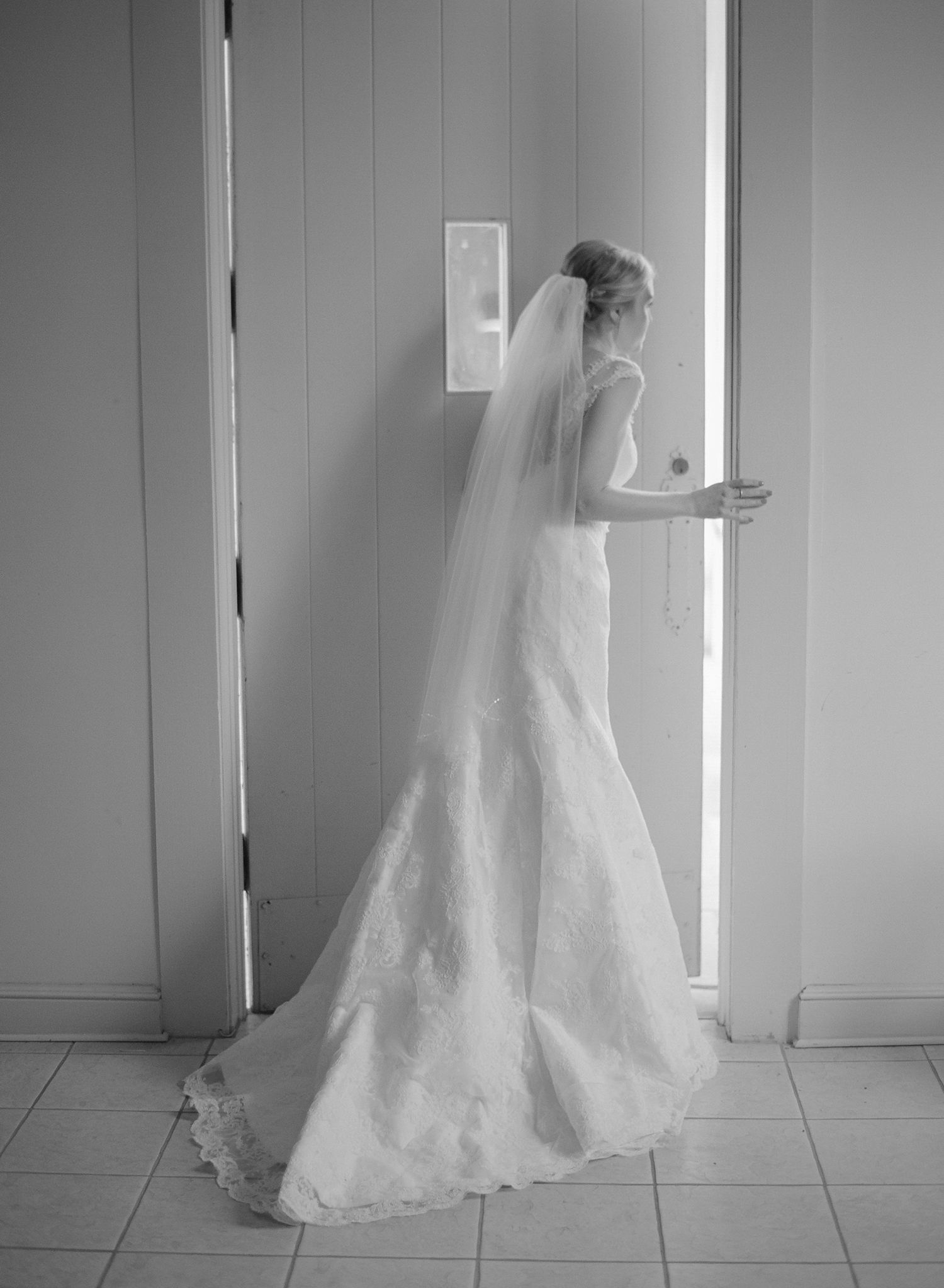 White lace wedding gown photographed in sequence against a light wall.