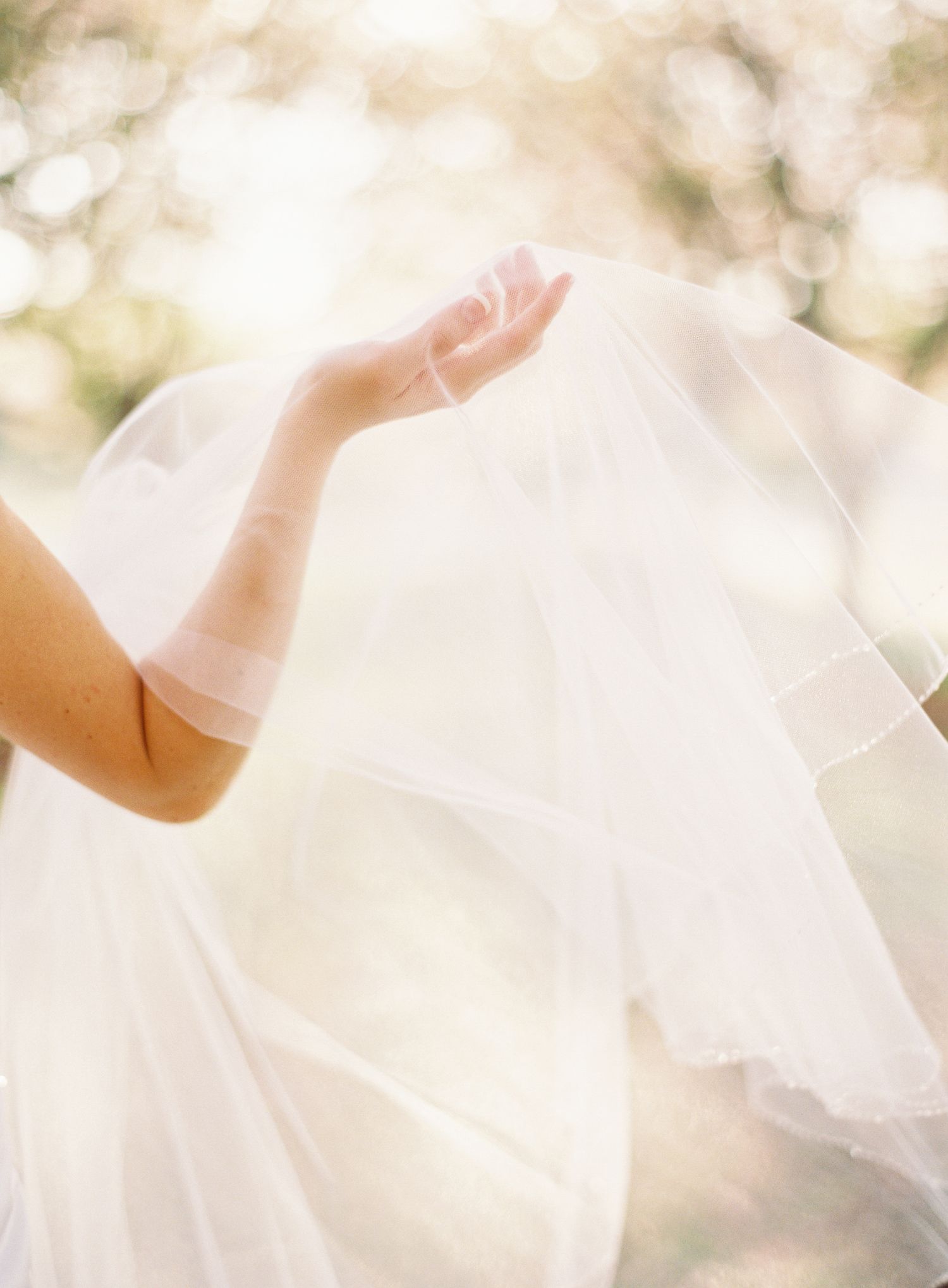 Ethereal white wedding dress fabric flowing in soft natural light.