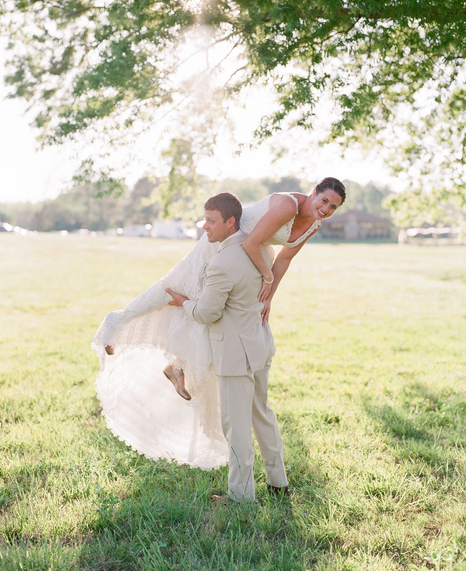 Wedding couple shares intimate moments in a sunlit meadow.