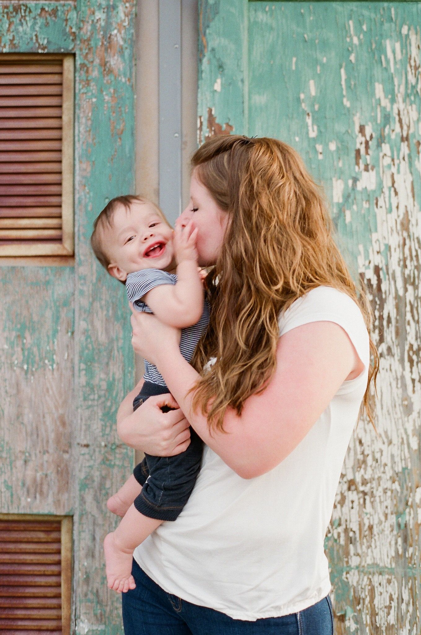 Playful sequence of photos against a weathered turquoise wall showing affectionate moments.