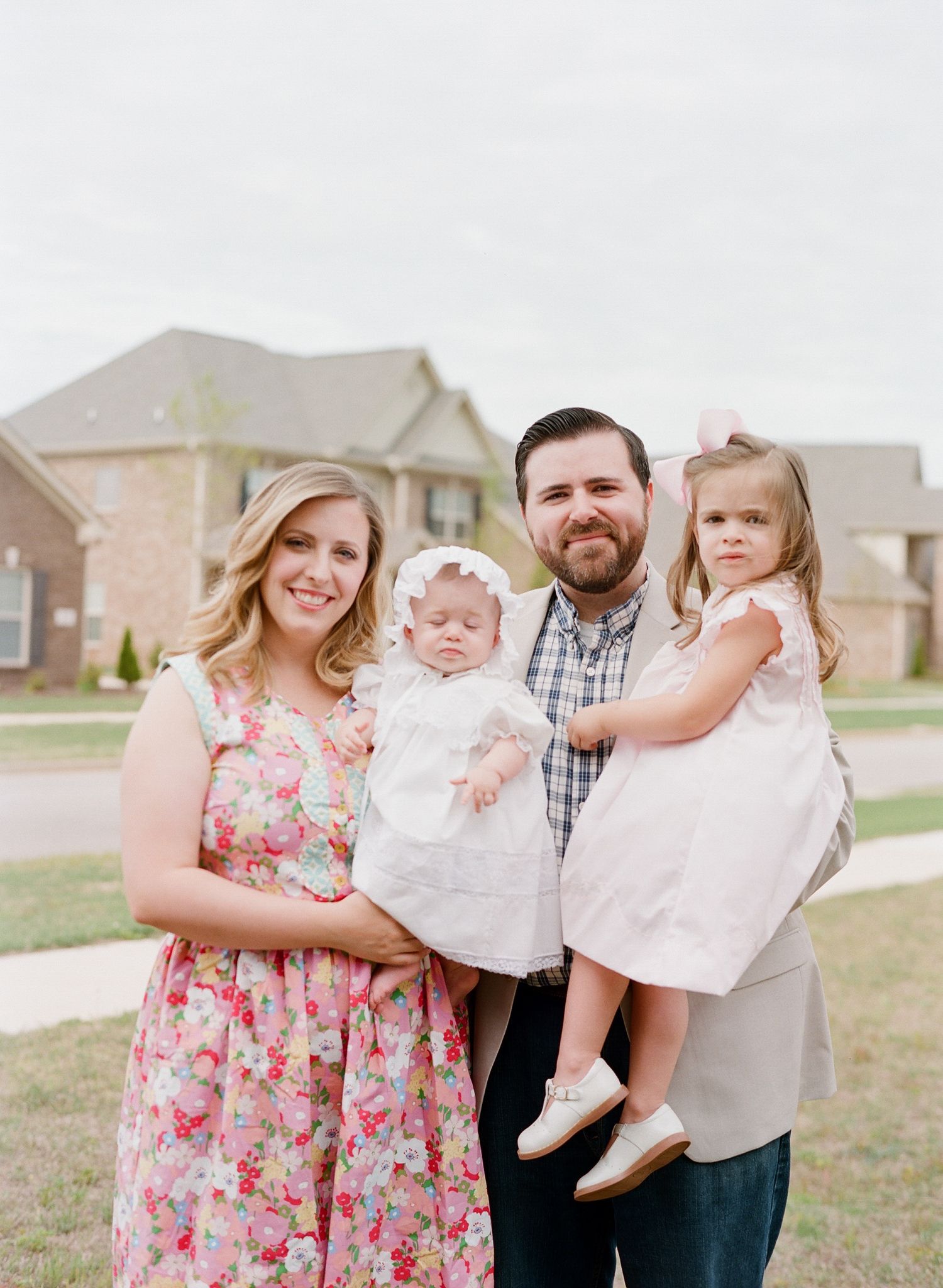 Family portrait series outdoors showing parents with young children in spring attire.