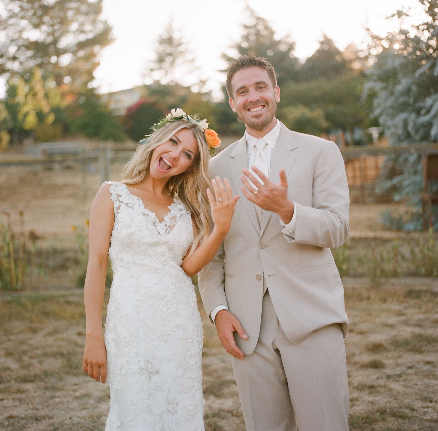 Newlyweds sharing a joyful moment together in an outdoor setting at sunset.