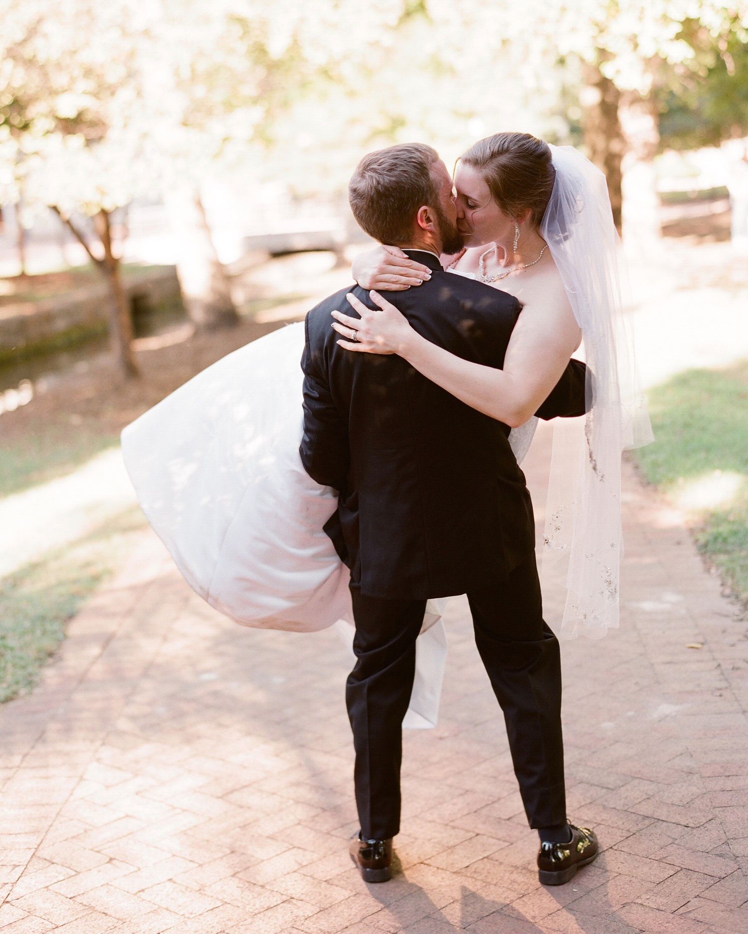 Series of playful dance moves between wedding couple on a stone pathway.