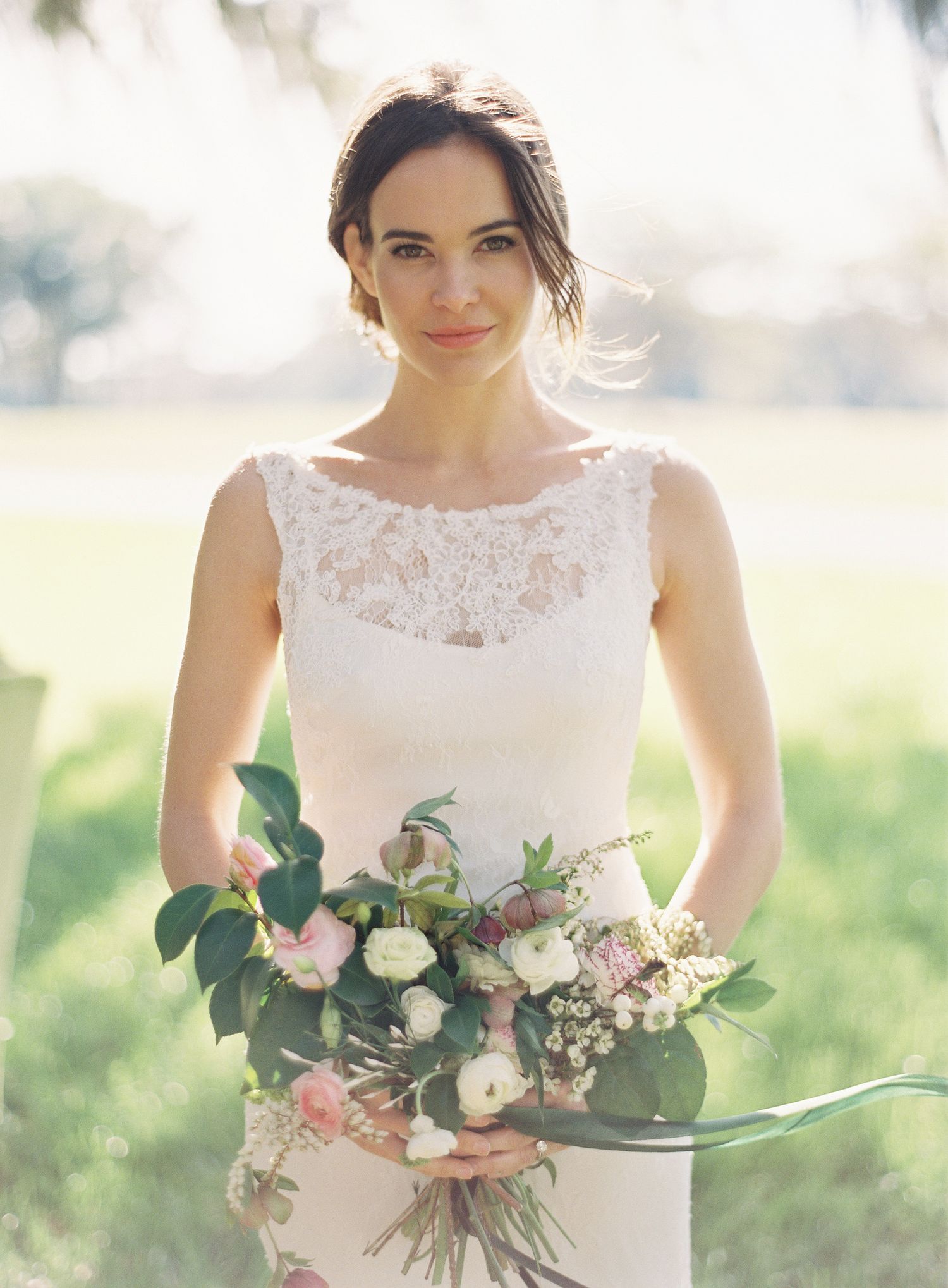Classic bridal portrait featuring delicate lace neckline and pastel floral bouquet.
