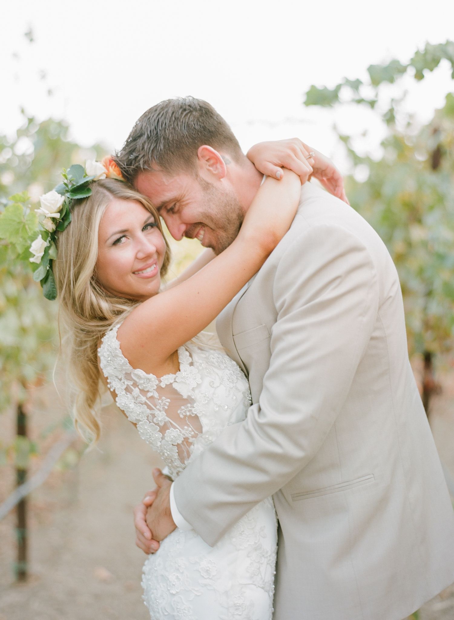 Newlyweds share an intimate dance among vineyard rows during their wedding photoshoot.