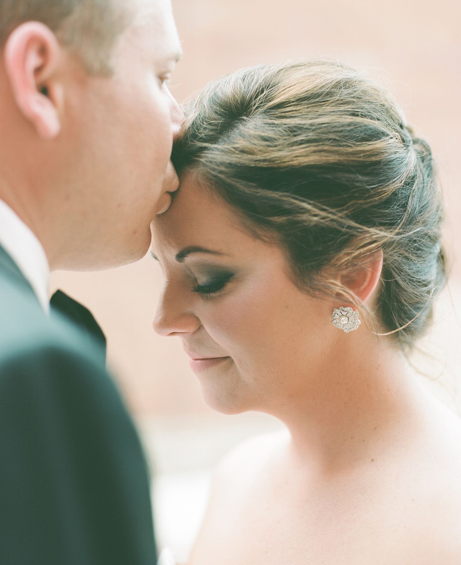Intimate close-up of a tender wedding moment in soft lighting.