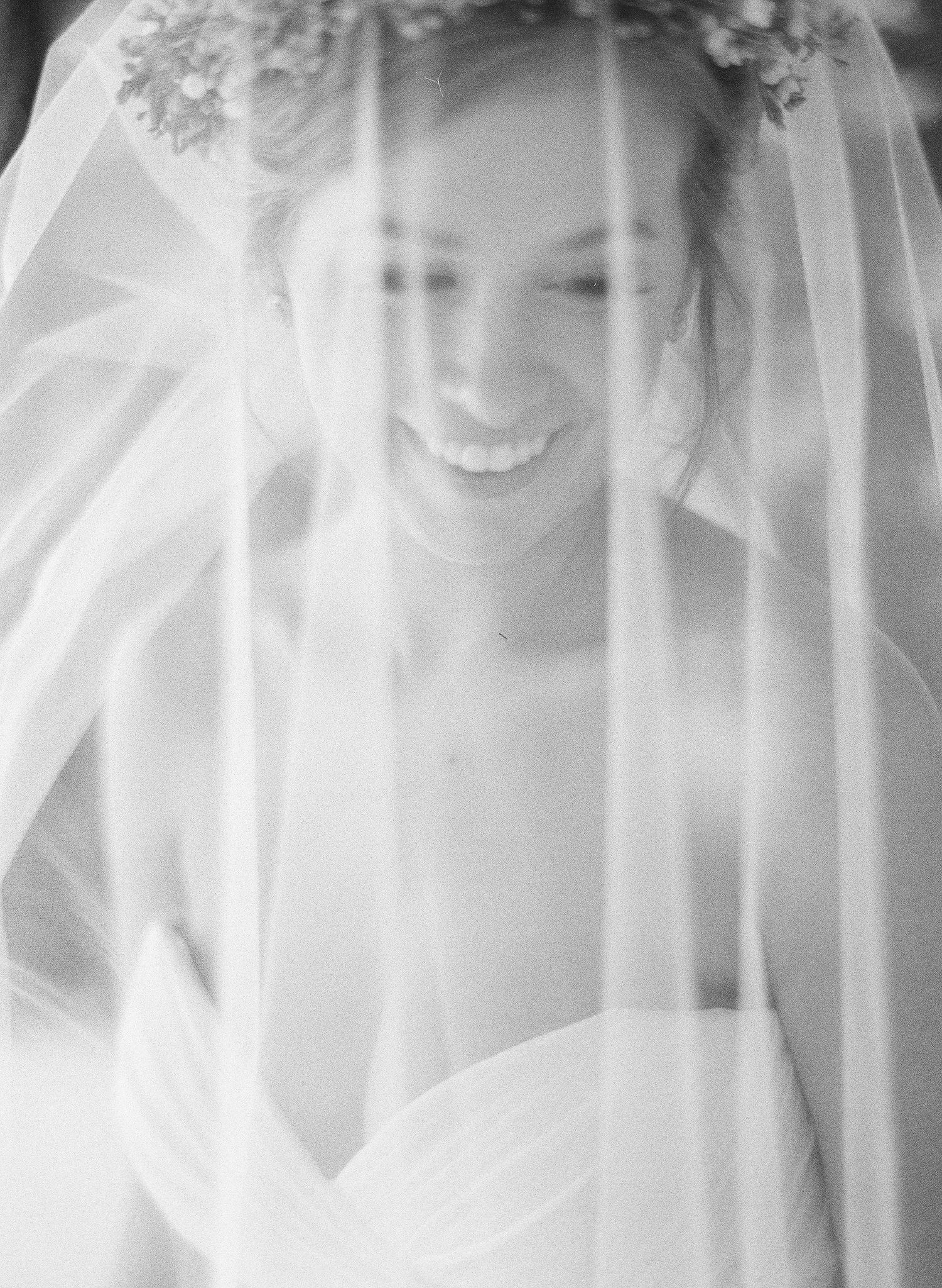 Ethereal bridal portraits through delicate white veil creating dreamy effect.