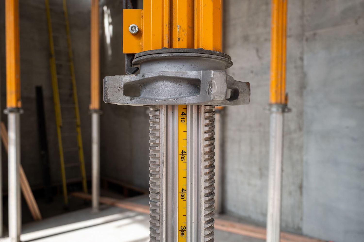 Detail shot of yellow metal construction supports and adjustment mechanisms.