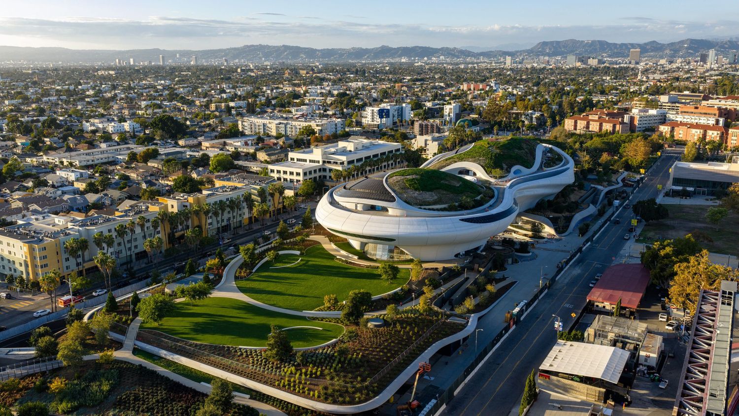 Bird's eye panoramic view of a modern sports venue with surrounding roads and urban development.