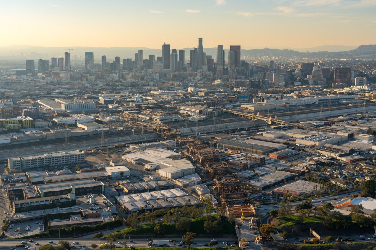 Panoramic cityscape showing downtown skyscrapers and industrial areas from an elevated perspective.
