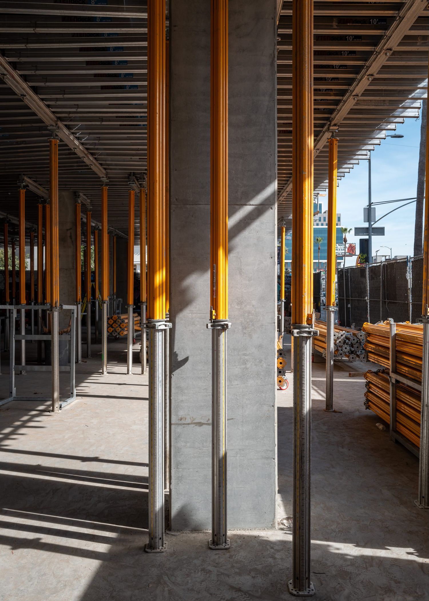 Empty construction area showing metal support columns and exposed ceiling infrastructure.