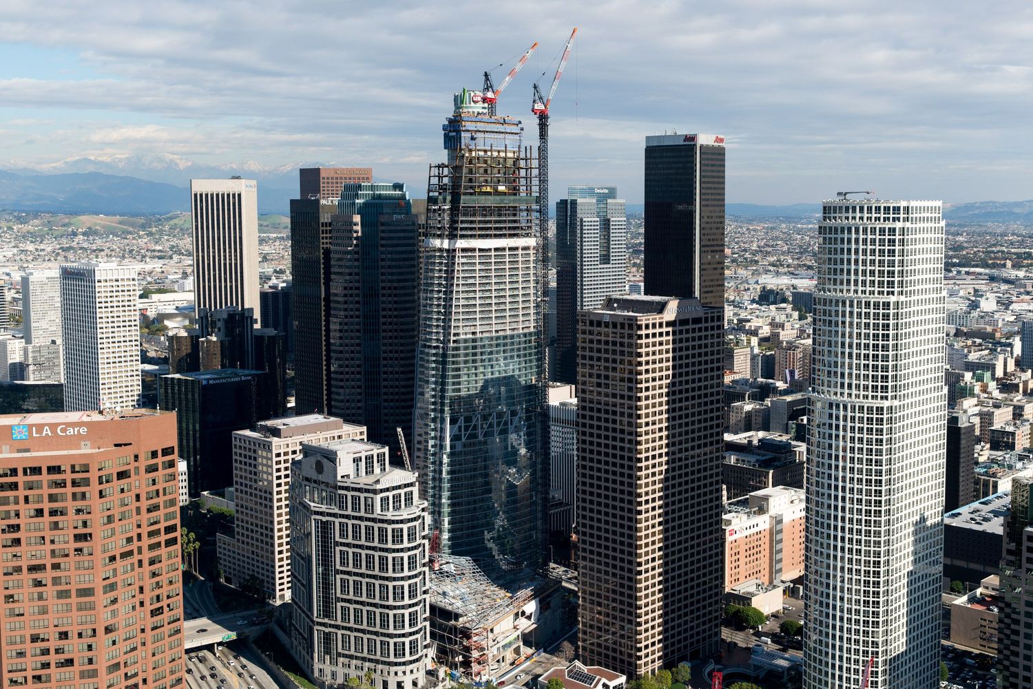 Panoramic view of downtown skyscrapers and high-rise buildings against cloudy sky.