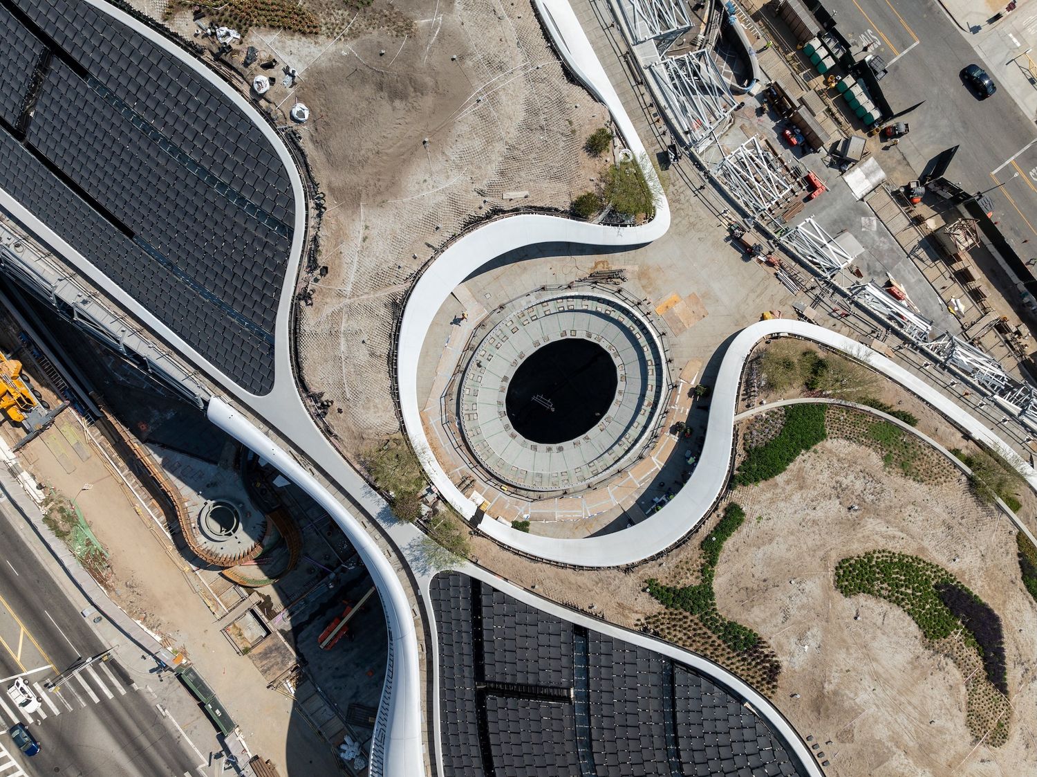Detailed aerial view of stadium's curved architectural elements and construction progress from above.