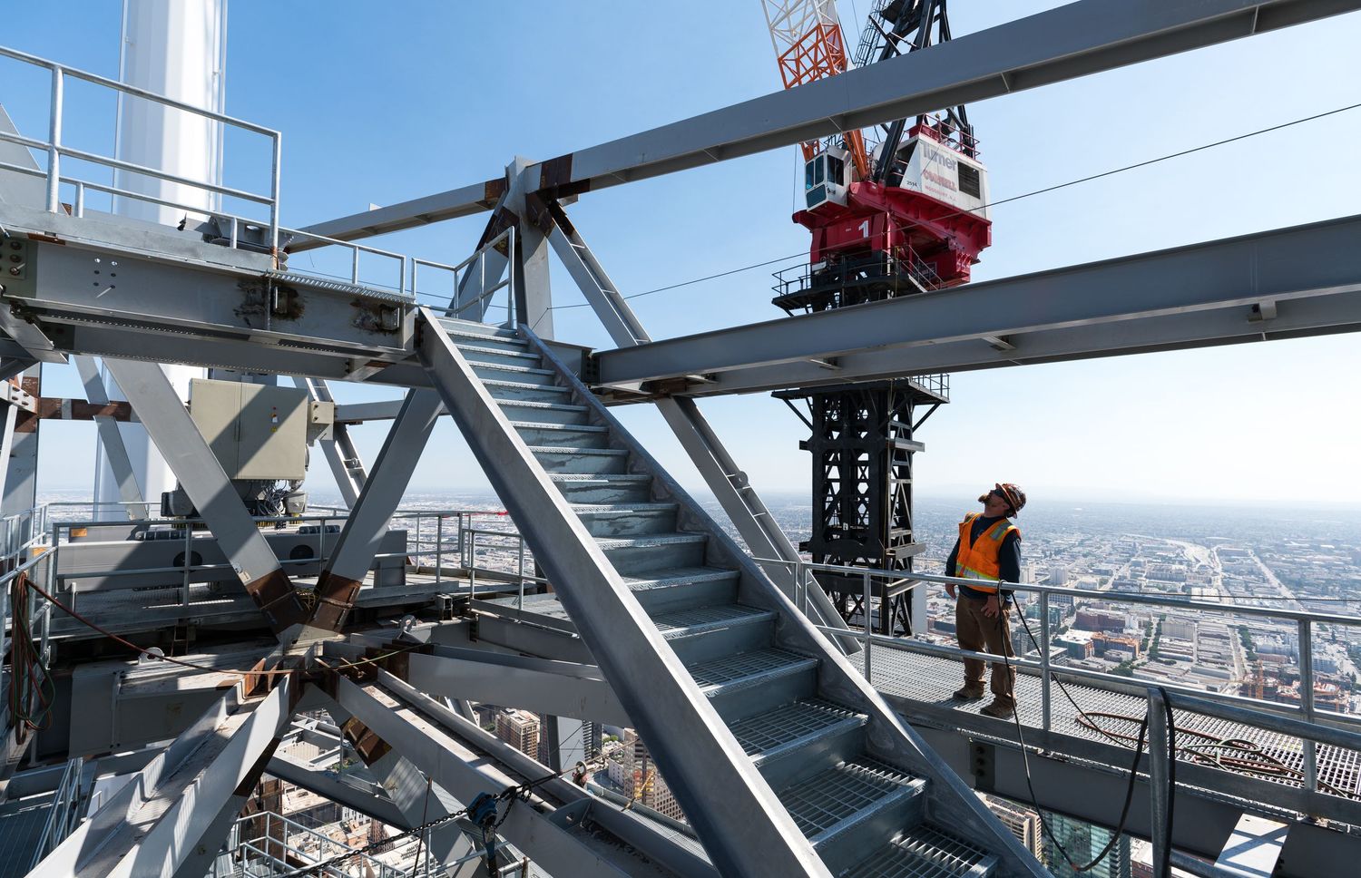 Steel beam construction workers walking on high-rise building framework with city views.