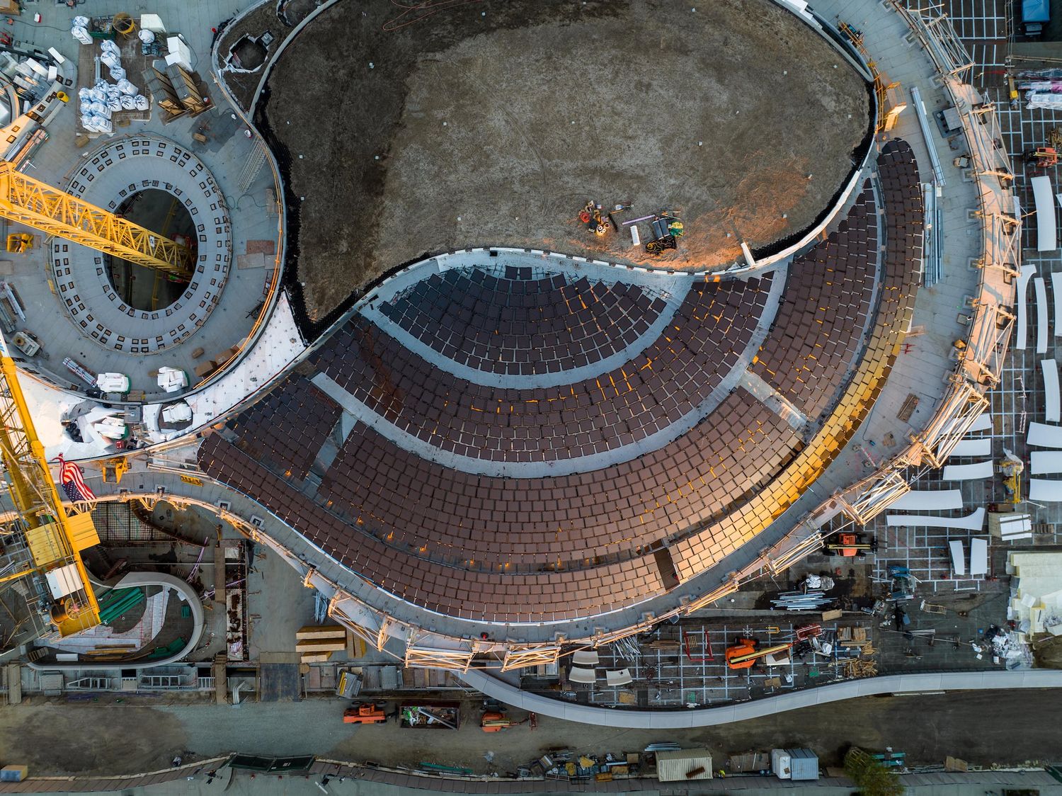 Overhead view of circular stadium construction showing detailed roof patterns and structural elements.