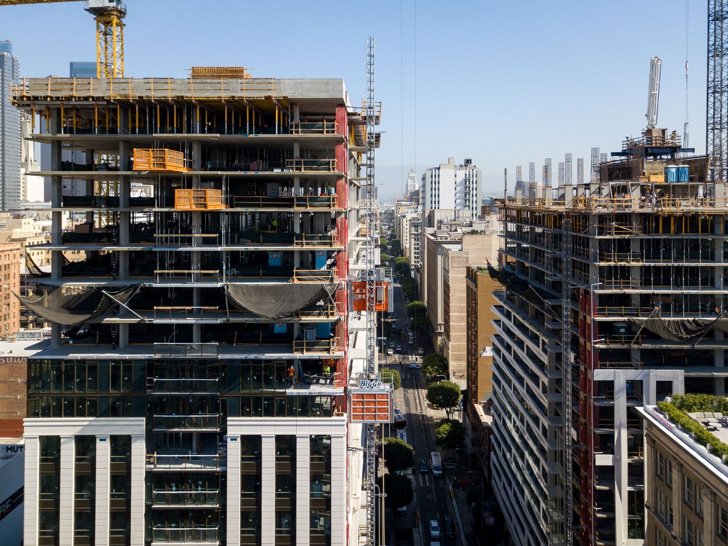 Urban construction site showing multiple high-rise buildings under development with tower cranes.