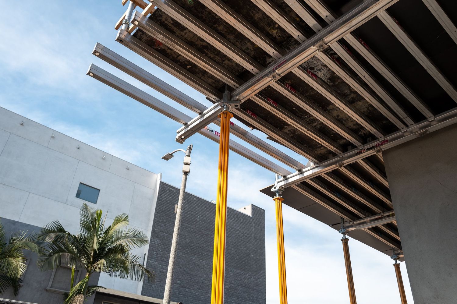 Construction site interior showing exposed ceiling beams and temporary support structures.