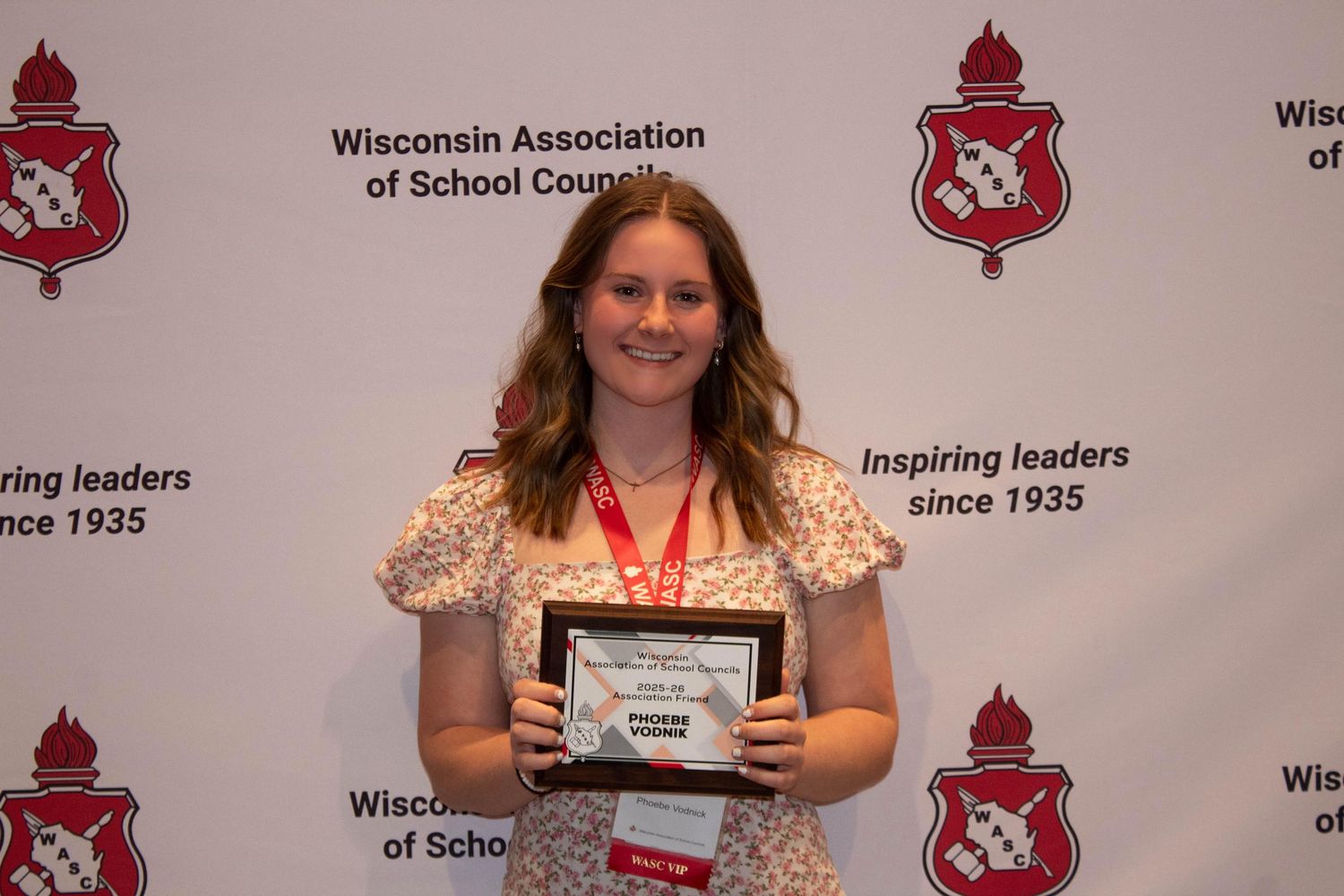 Student holds award plaque at Wisconsin Association of School Councils inspiring leaders event.