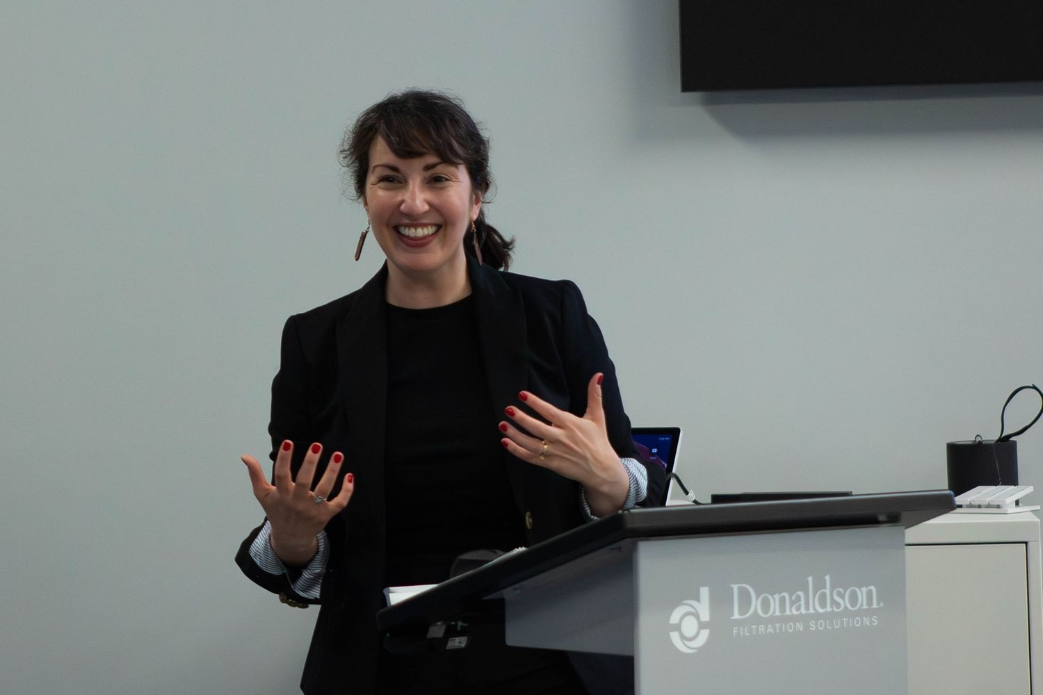 Woman in black blazer speaking at a Donaldson podium during a professional conference.