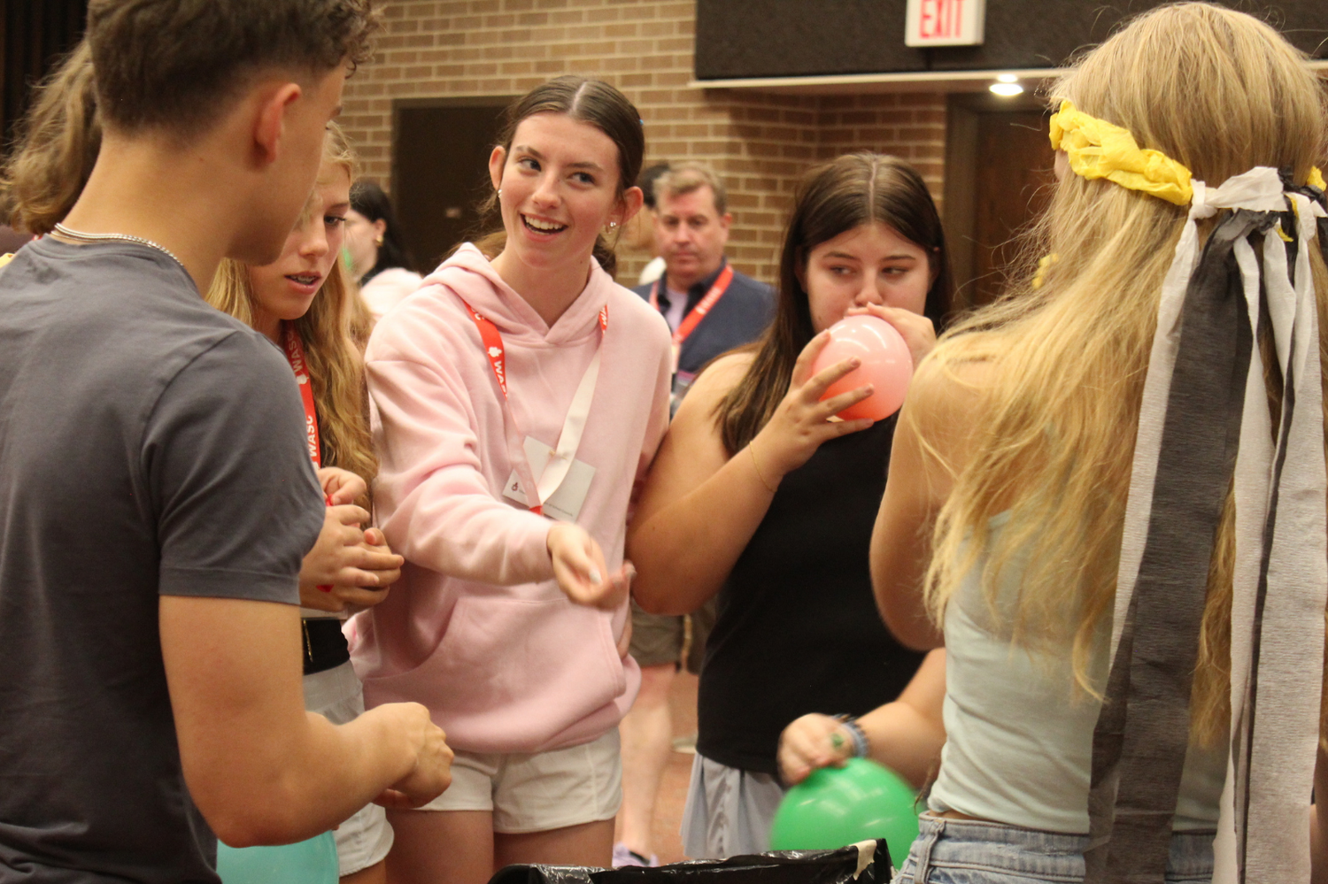 Students interact and play with balloons at an indoor campus social mixer or orientation activity event.